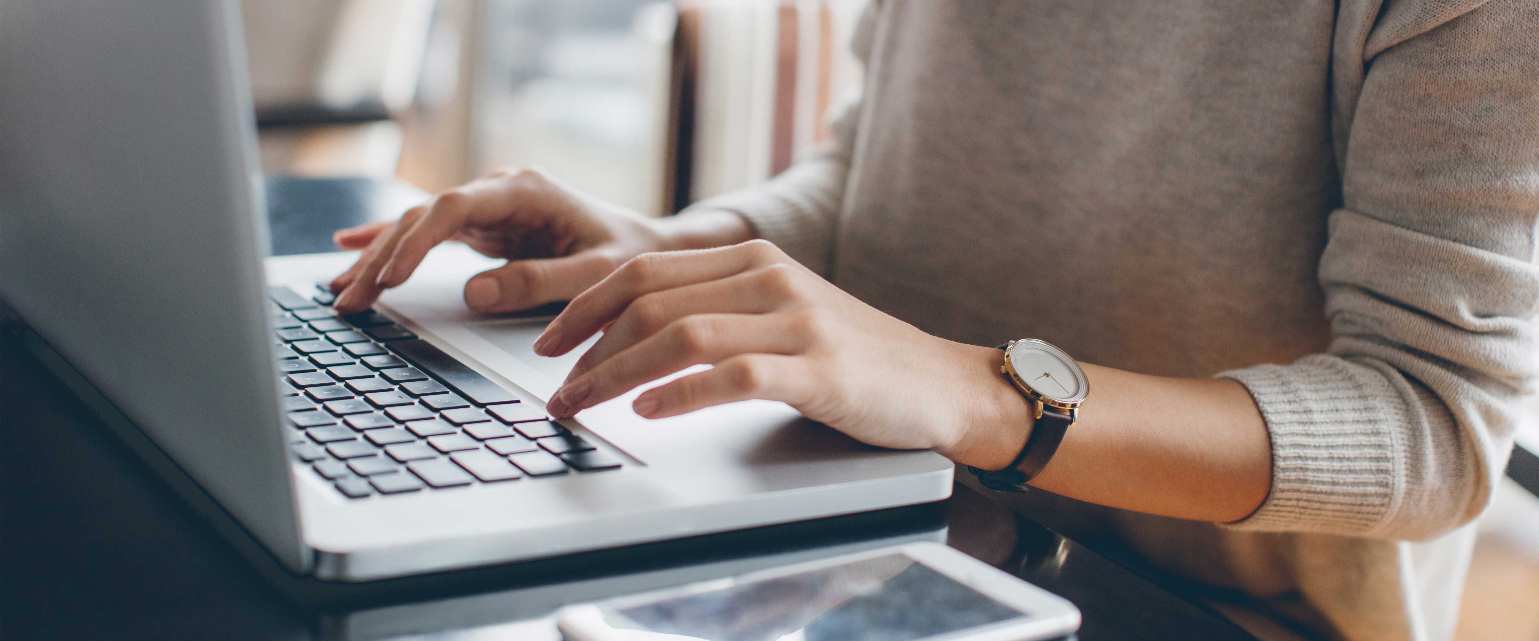 Closeup of a woman typing on a laptop