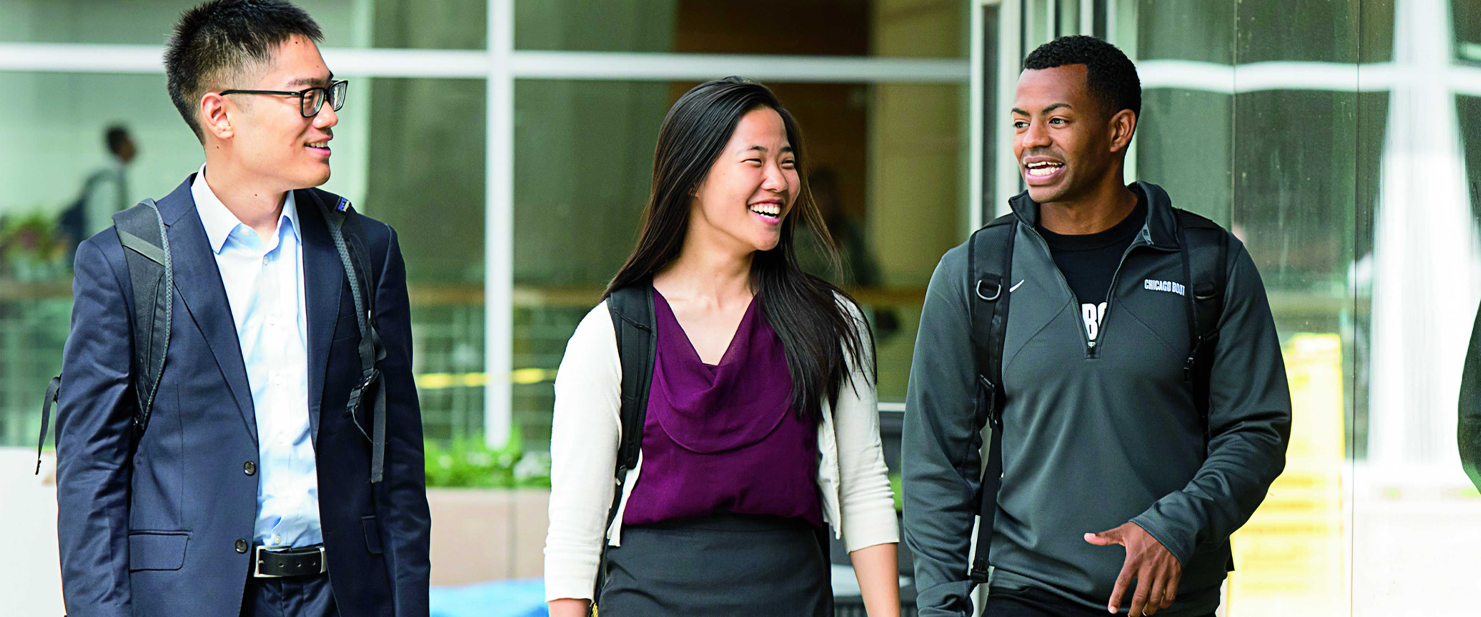 Three Chicago Booth students walking through the Summer Garden at the Harper Center