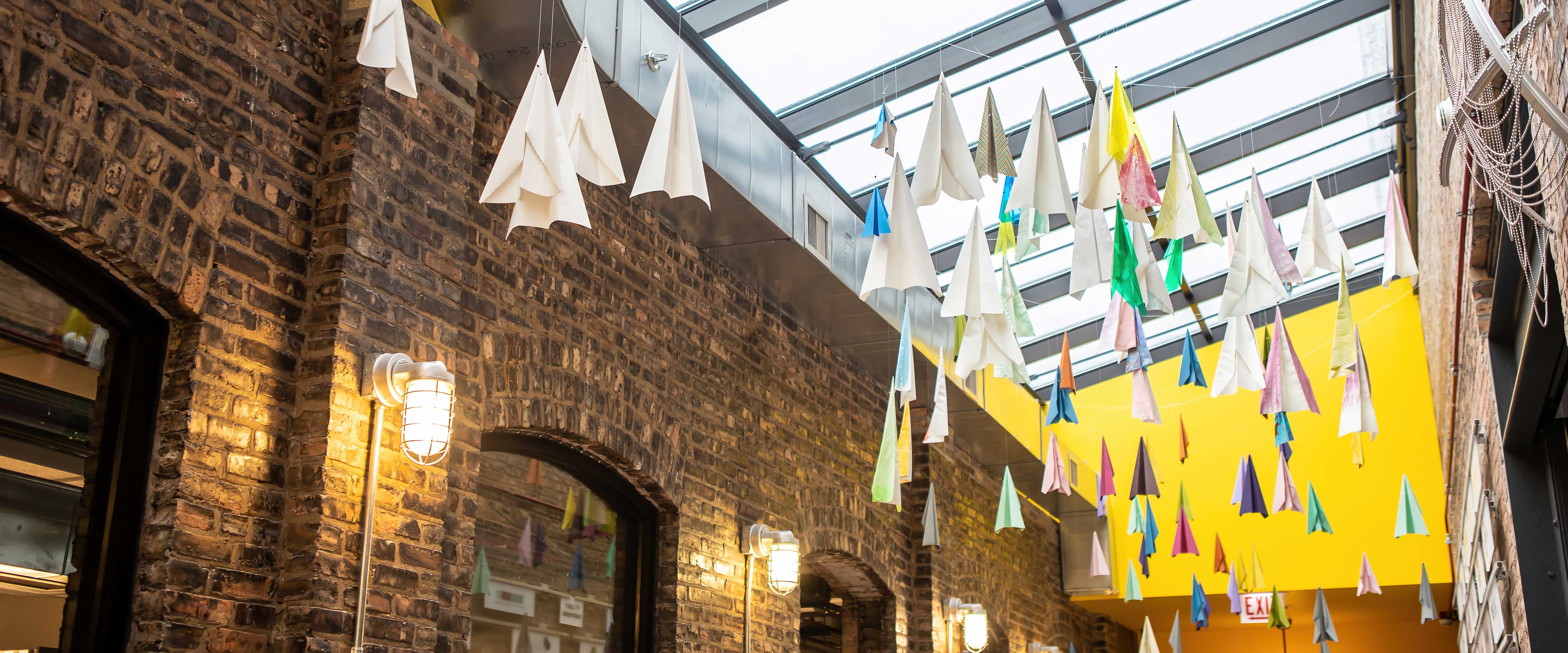 Paper airplanes hanging from the Polsky Exchange ceiling