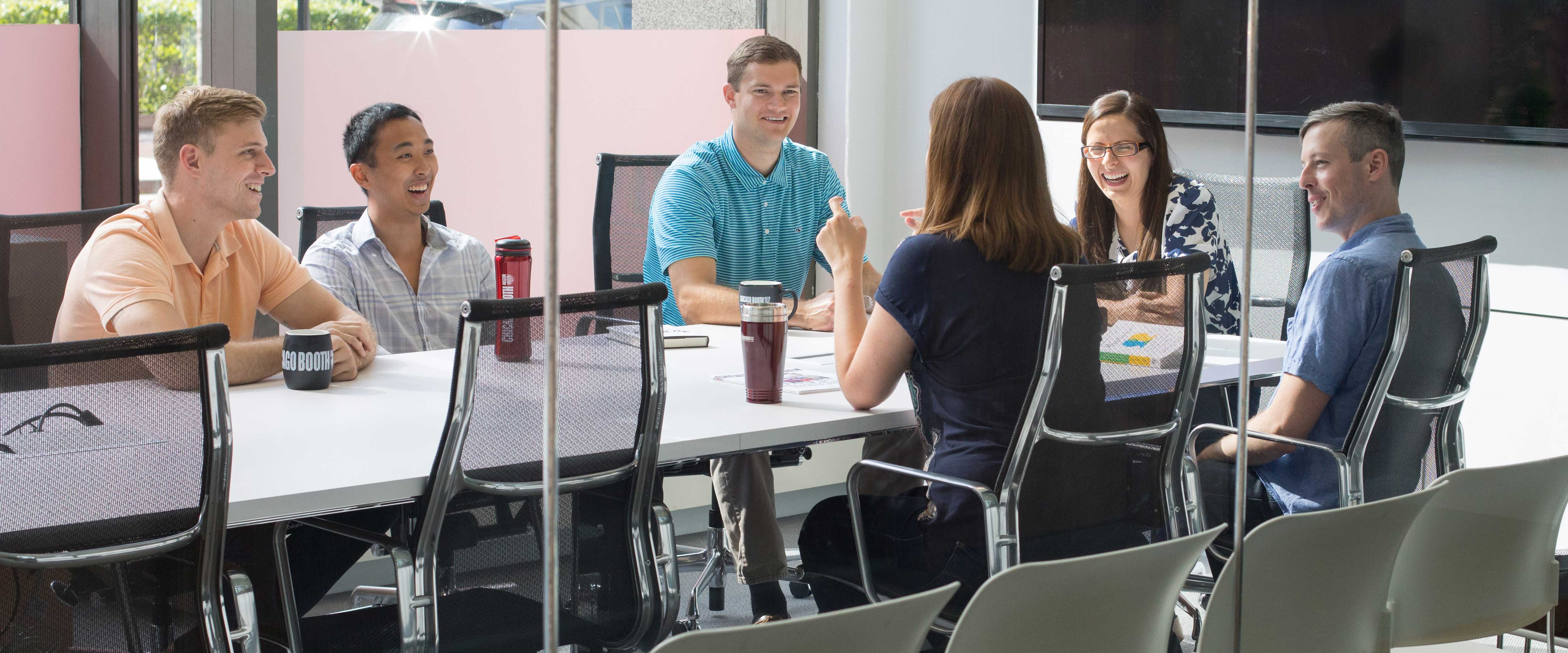 Students sitting at a table in a confernece room