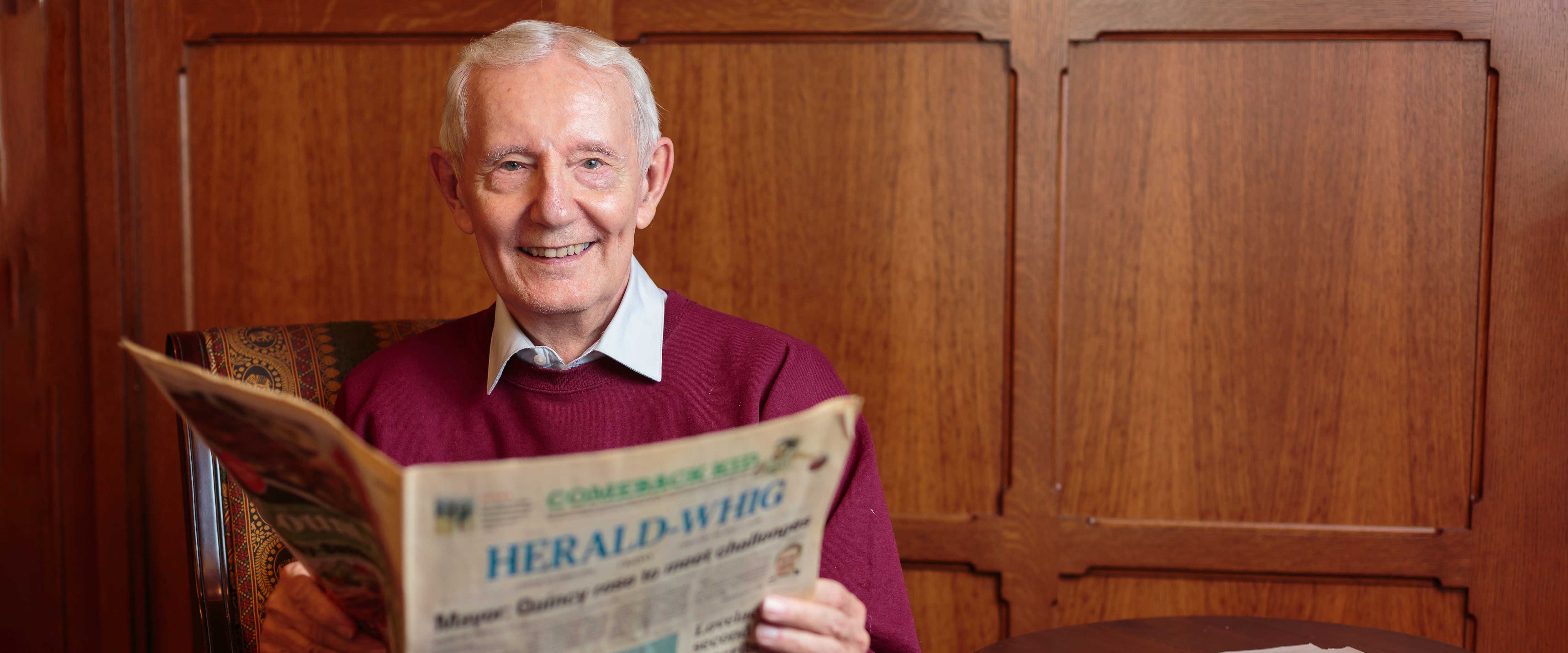Dennis Williams reading a newspaper