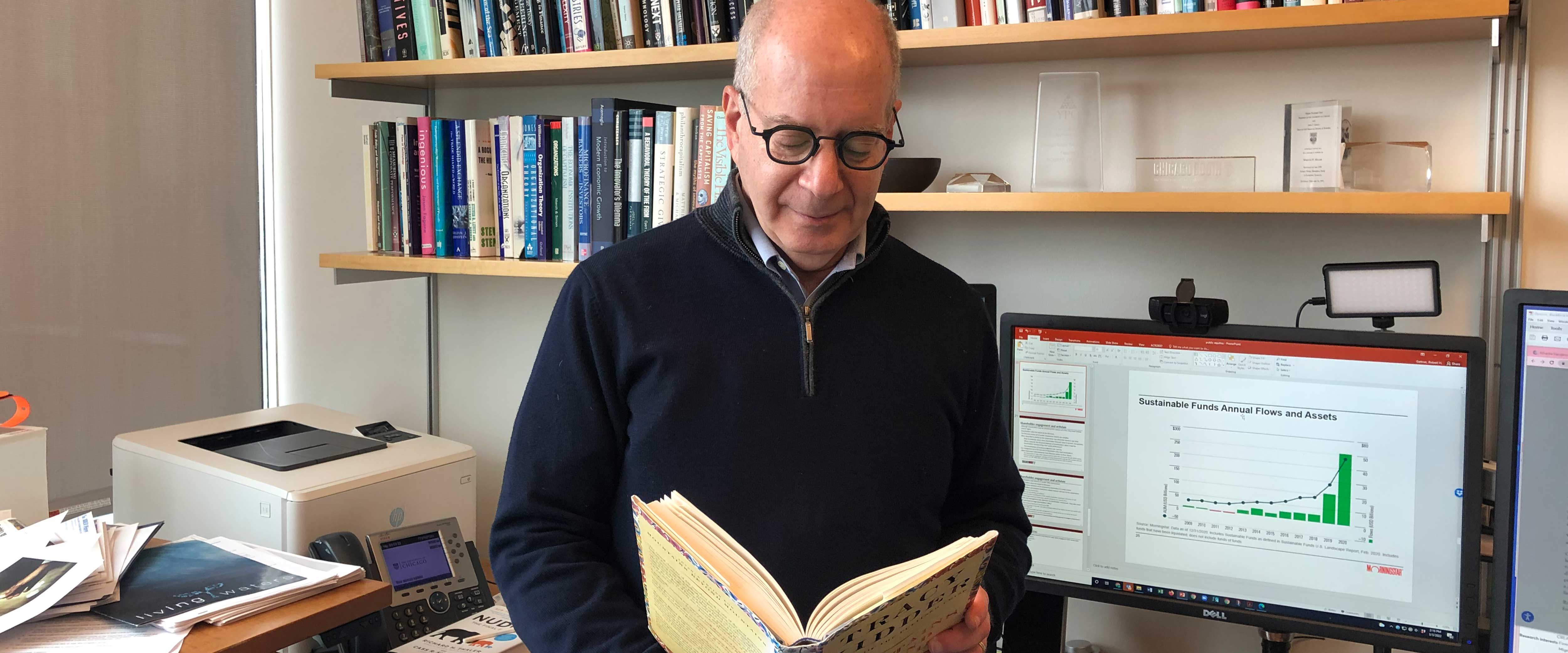 Robert Gertner reading a book in his office