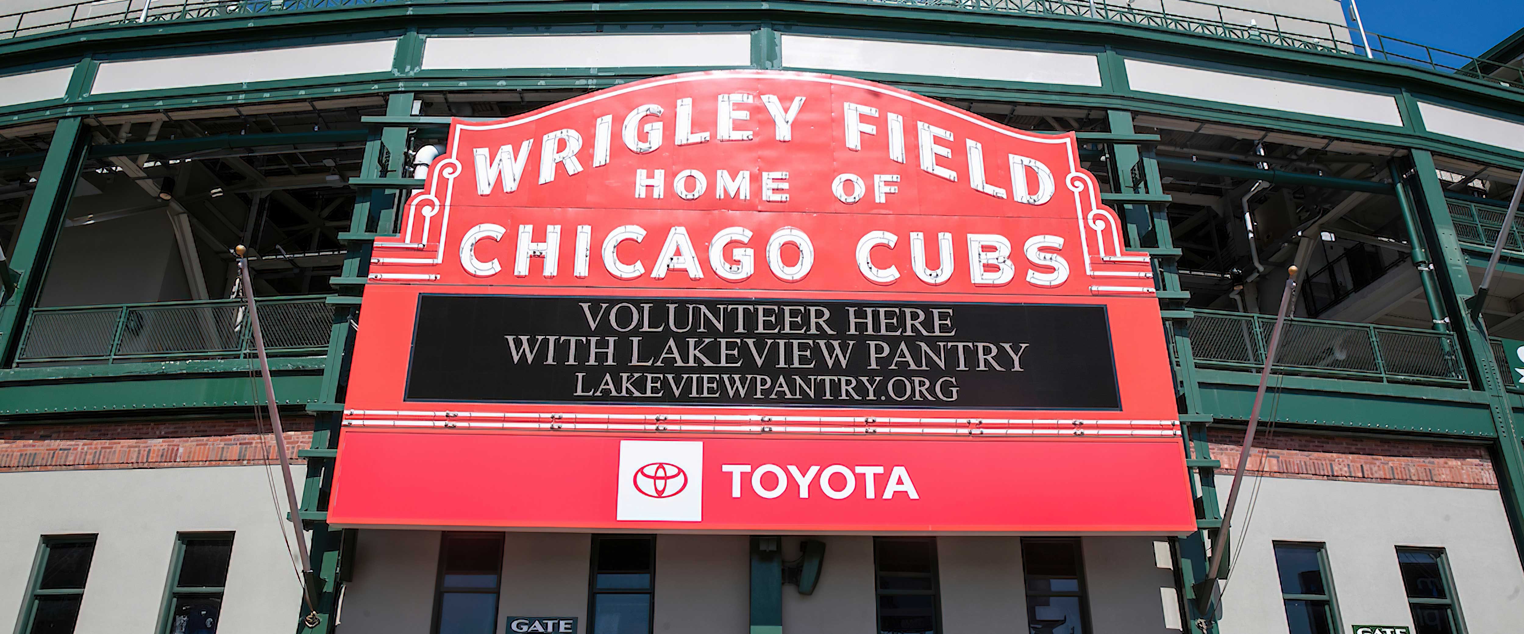 Volunteers standing with Lakeview Pantry and Chicago Cubs partnership sign