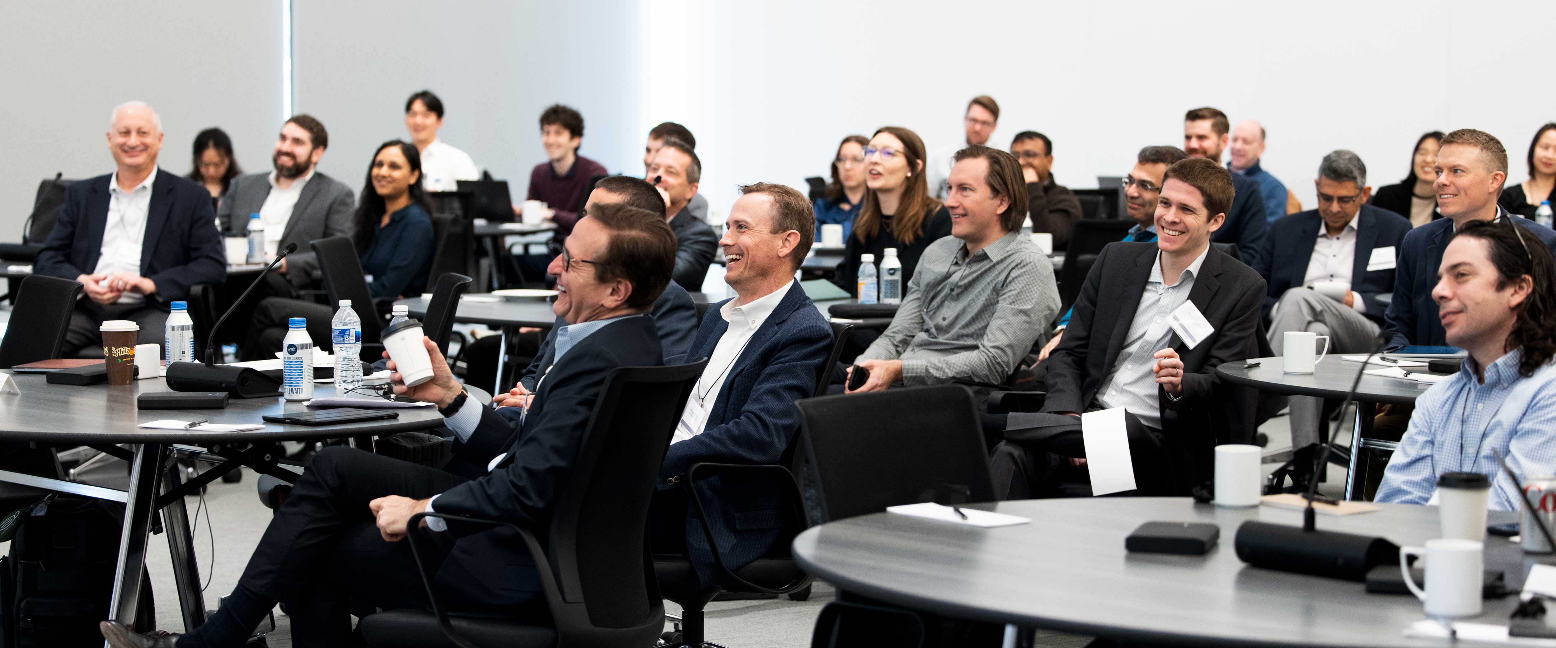 Laughing audience at the Symposium on Private Firms 