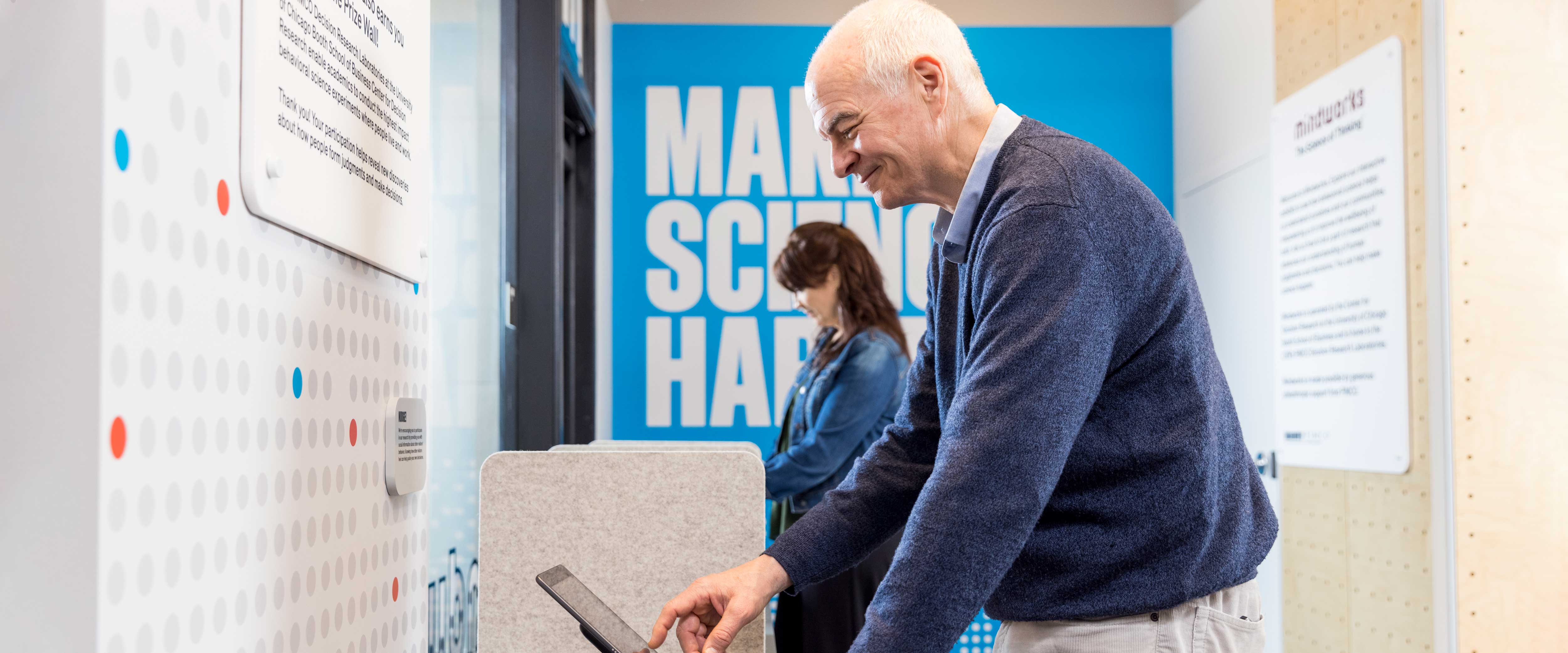A man using an iPad in an exhibit
