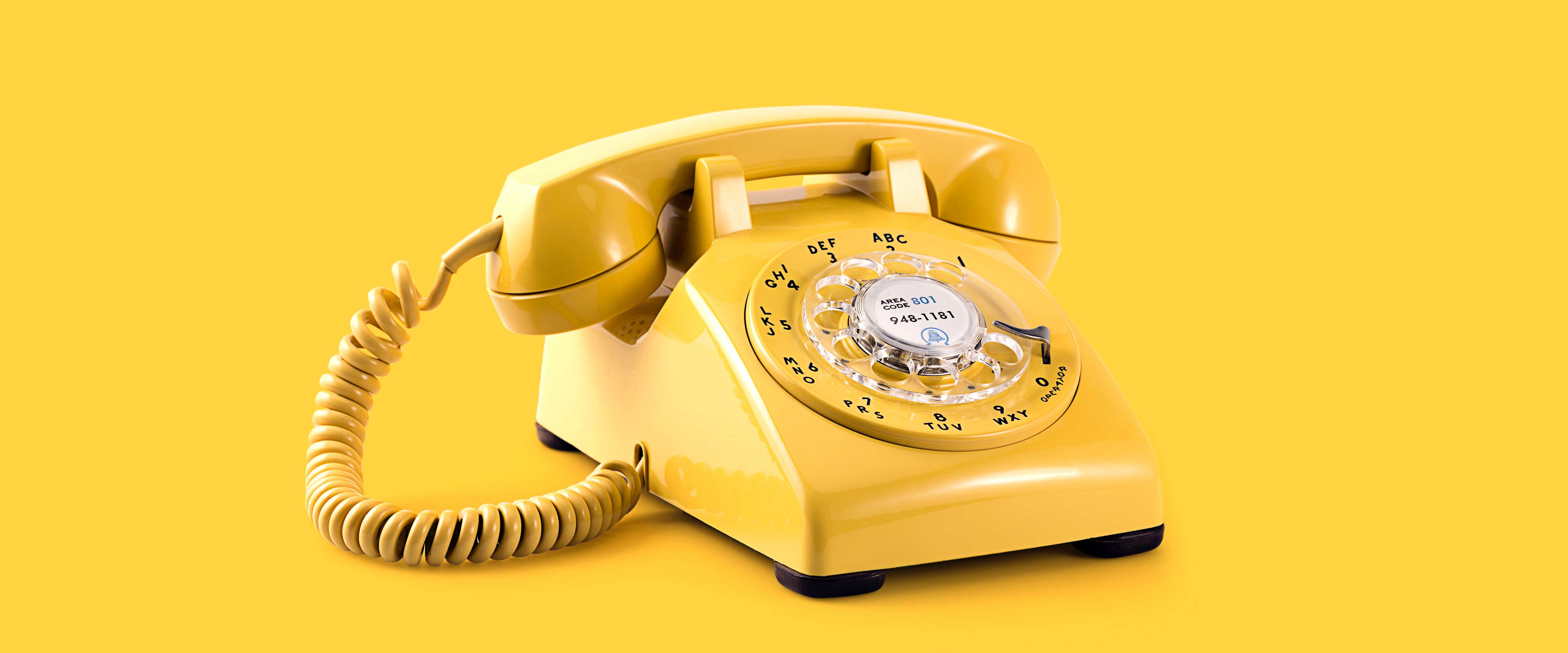 Vintage yellow phone on a yellow background