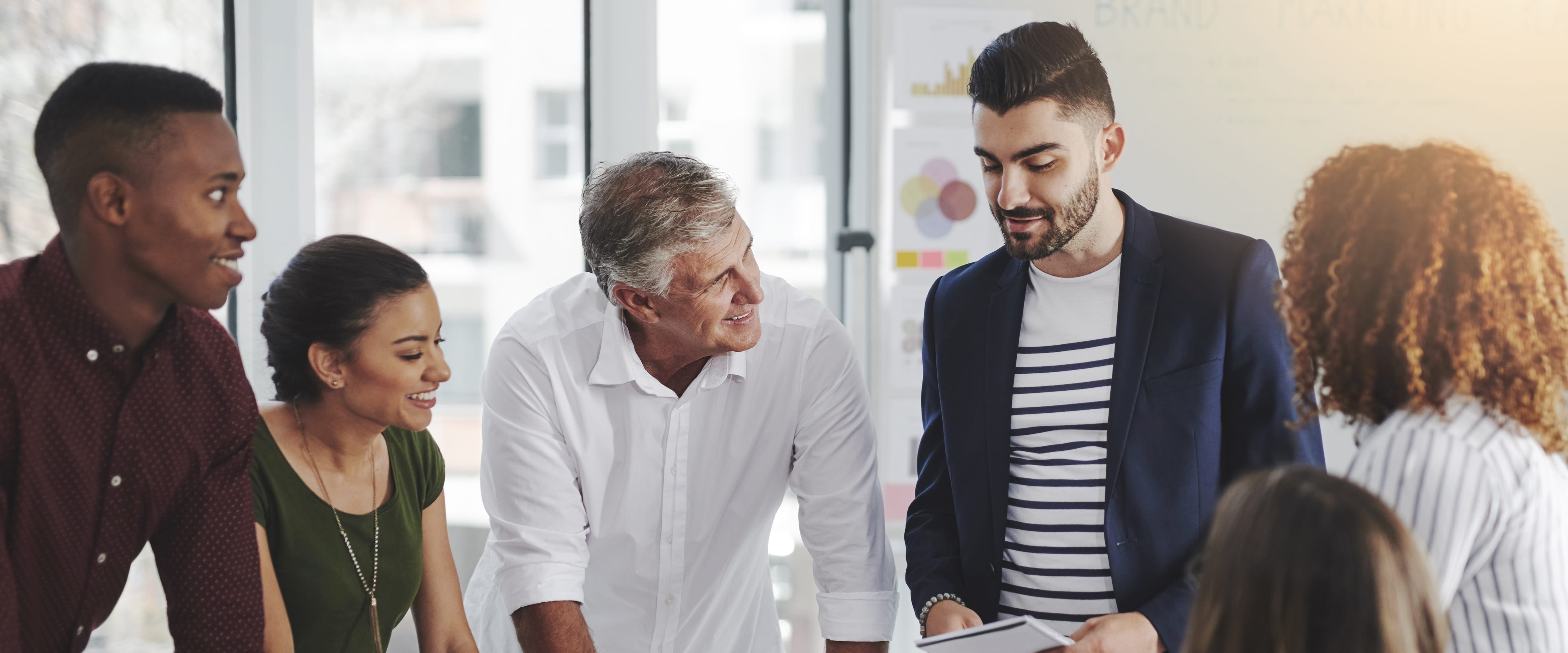 Group of people standing around engaged in a conversation.
