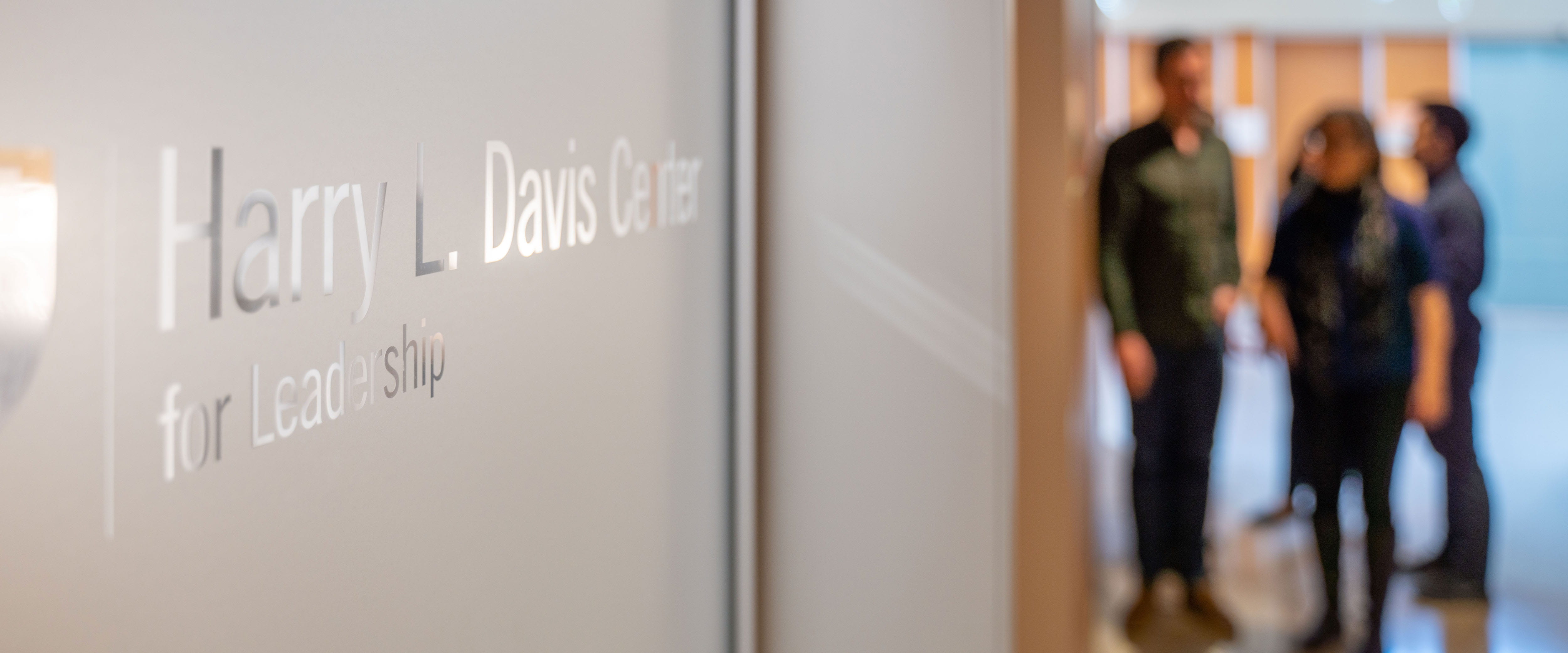 Frosted door with Harry Davis center logo, with blurred students in the background