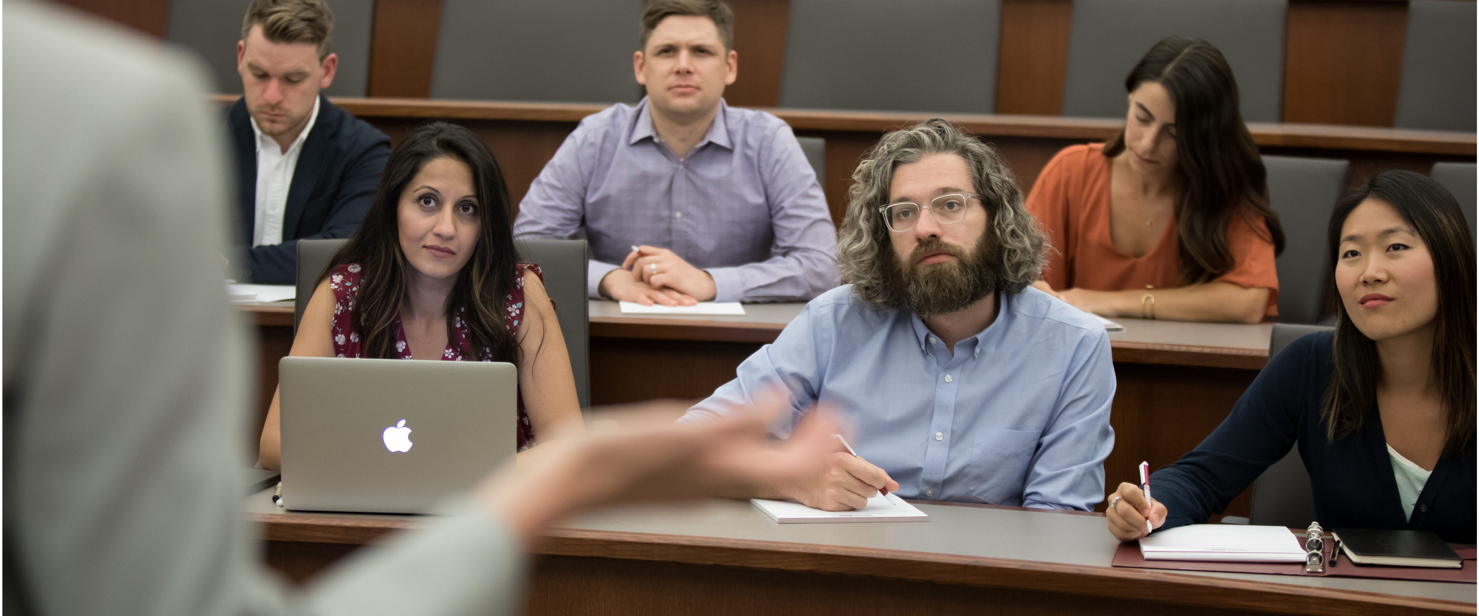 Booth leadership MBA students attentively taking notes during lecture