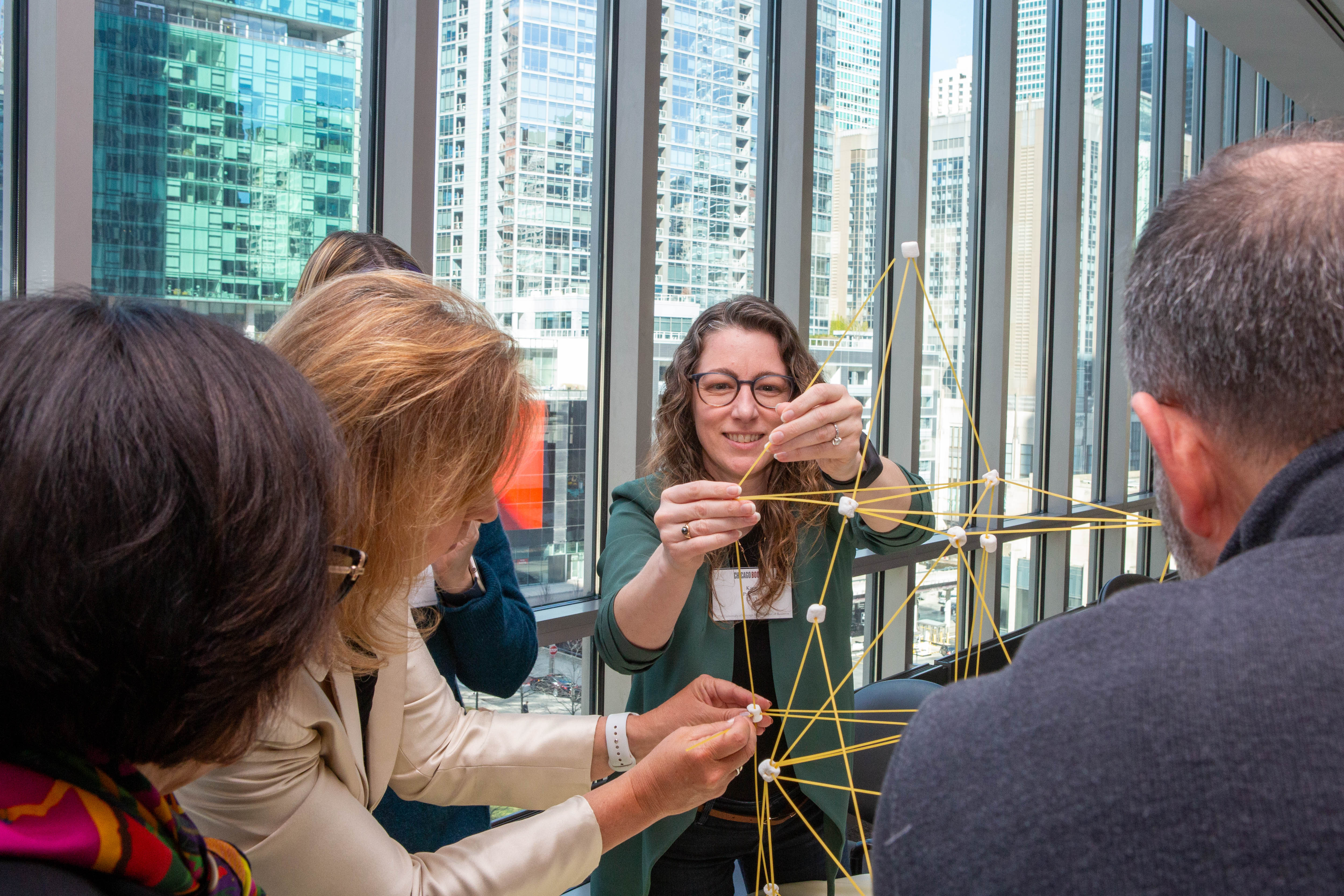 Group of alumni completing the "marshmallow challenge"