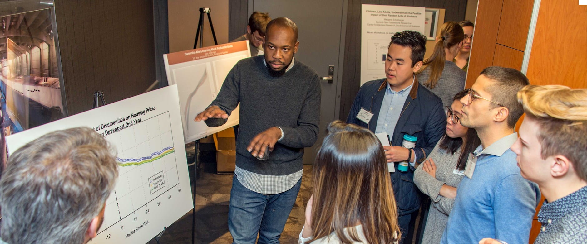 Person presenting behavioral science research on a poster board
