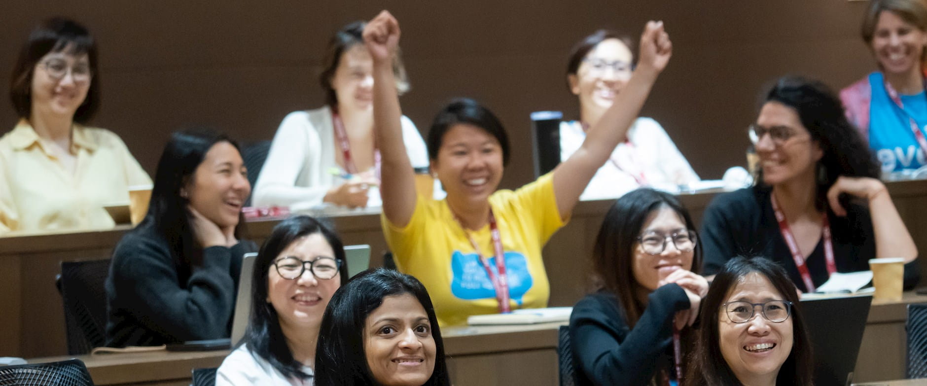 Classroom with people smiling and one person raising arms