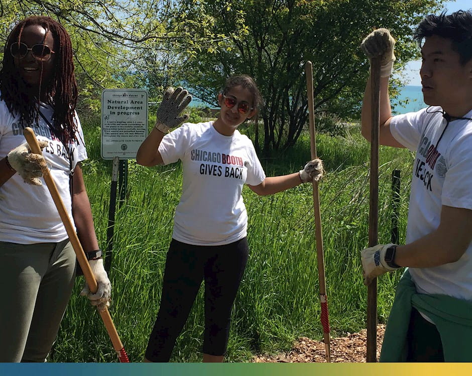 Chicago Booth Gives Back volunteers working outside in a Chicago Park District Natural Development Area with trees and grass by the lake