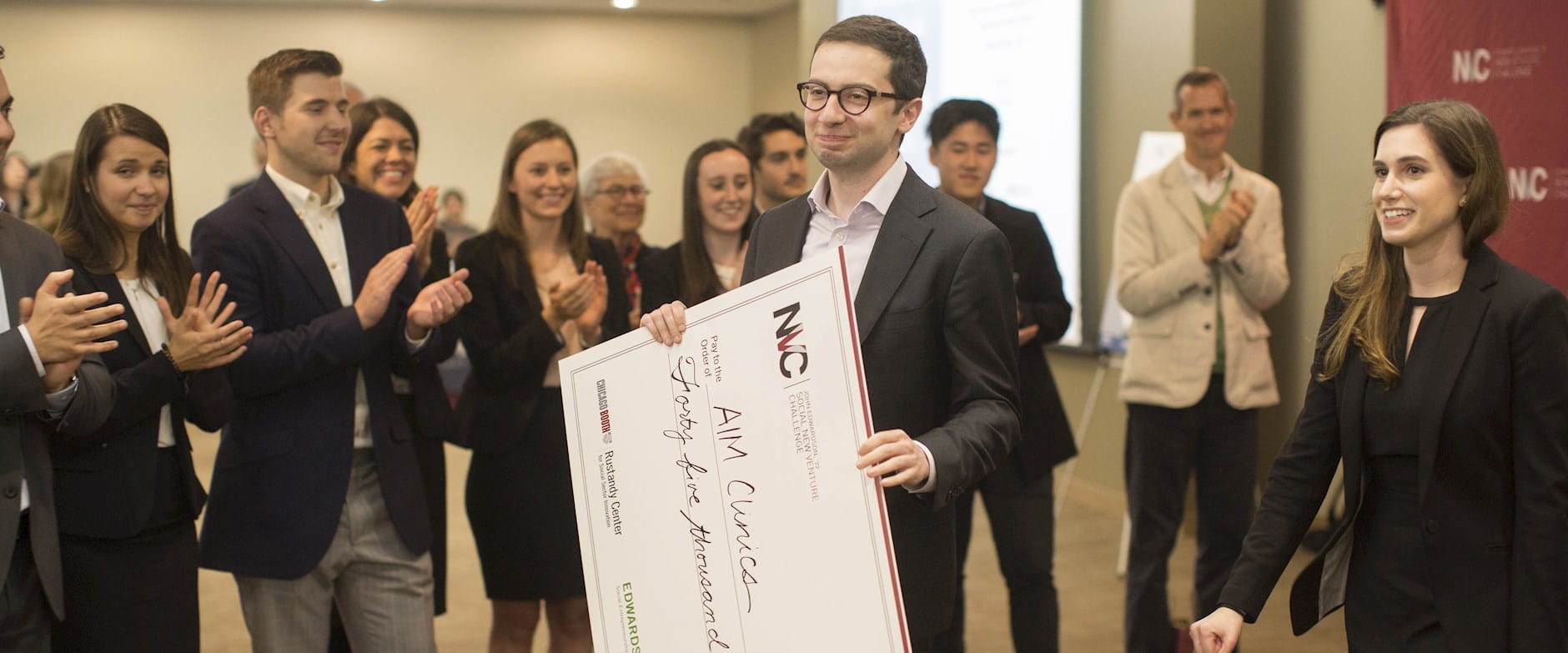 AIM cofounder George Boghos holds a giant check after winning SNVC 2018