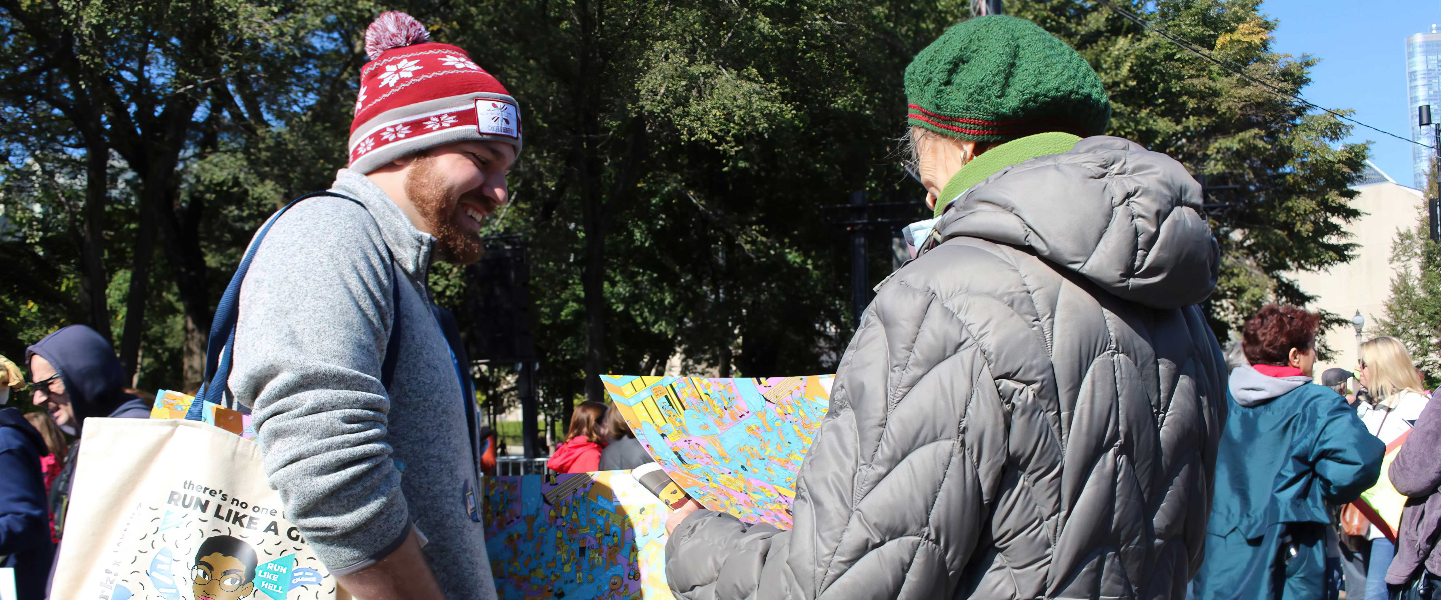 Jake Mikva talks to a gray-haired woman outside during the wintertime