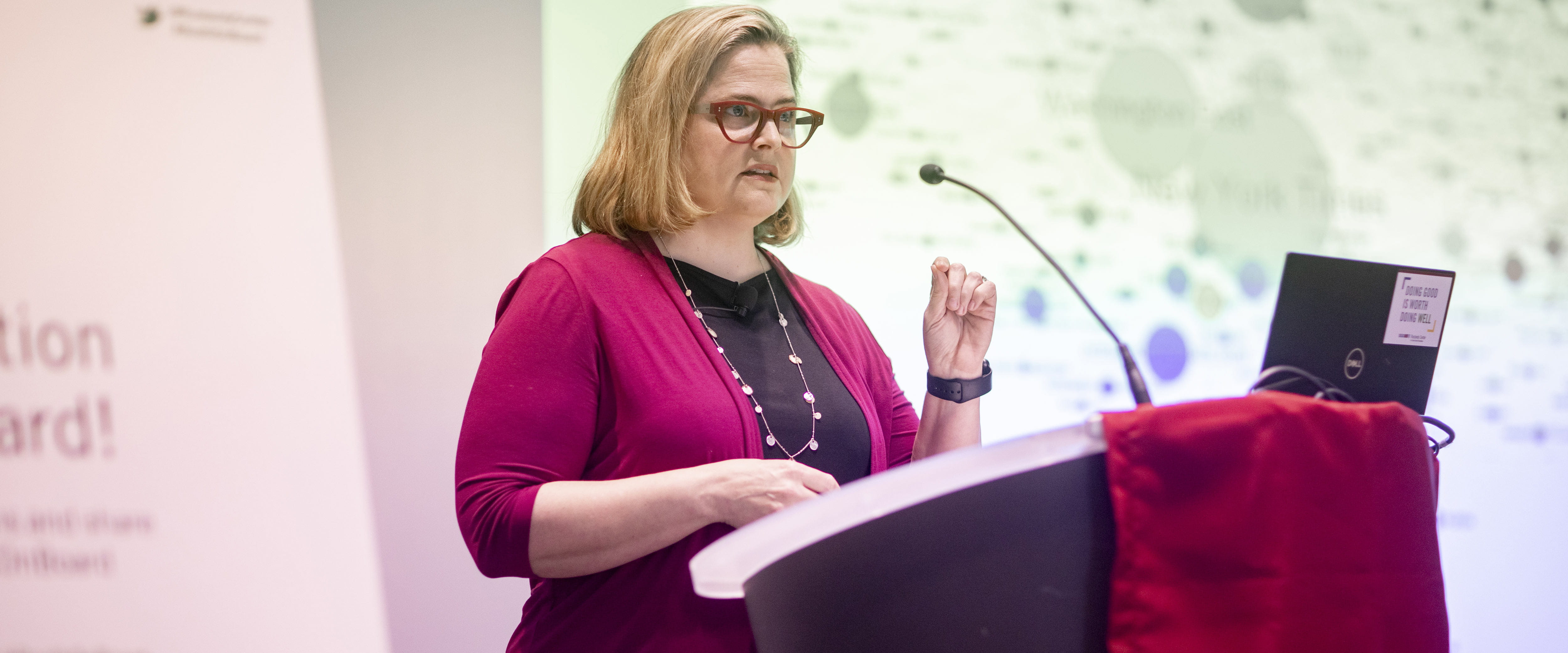 Alisa Miller speaking at a podium at Rustandy Center's On Board conference