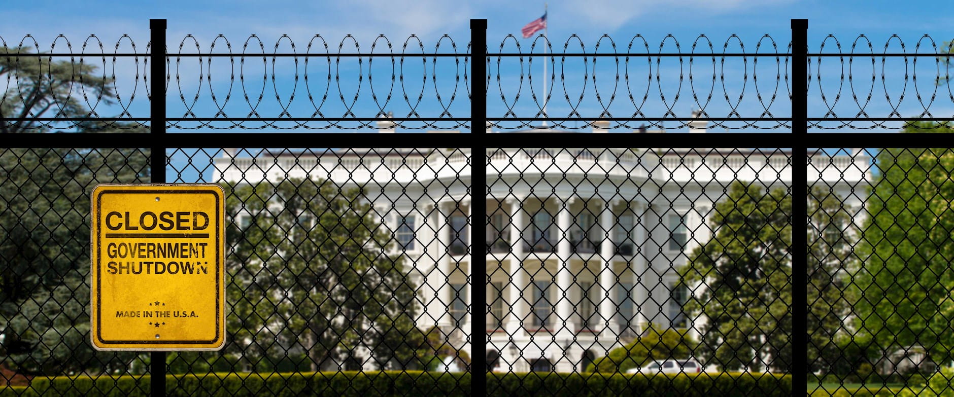 The White House behind a barbed wire fence; a yellow sign to the left reads "Closed | Government Shutdown"