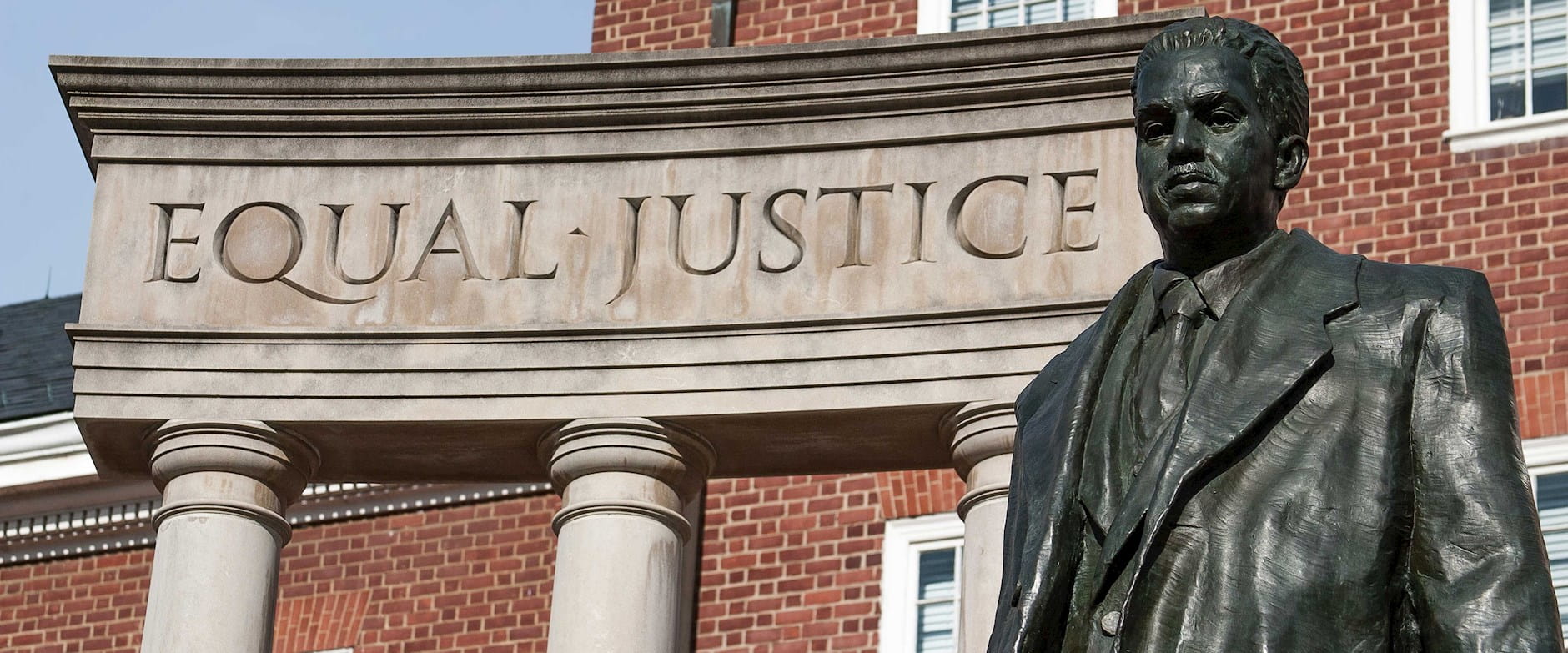 A statue of Thurgood Marshall at a memorial outside the Maryland State House - a concrete piece of the artwork reads "Equal Justice"