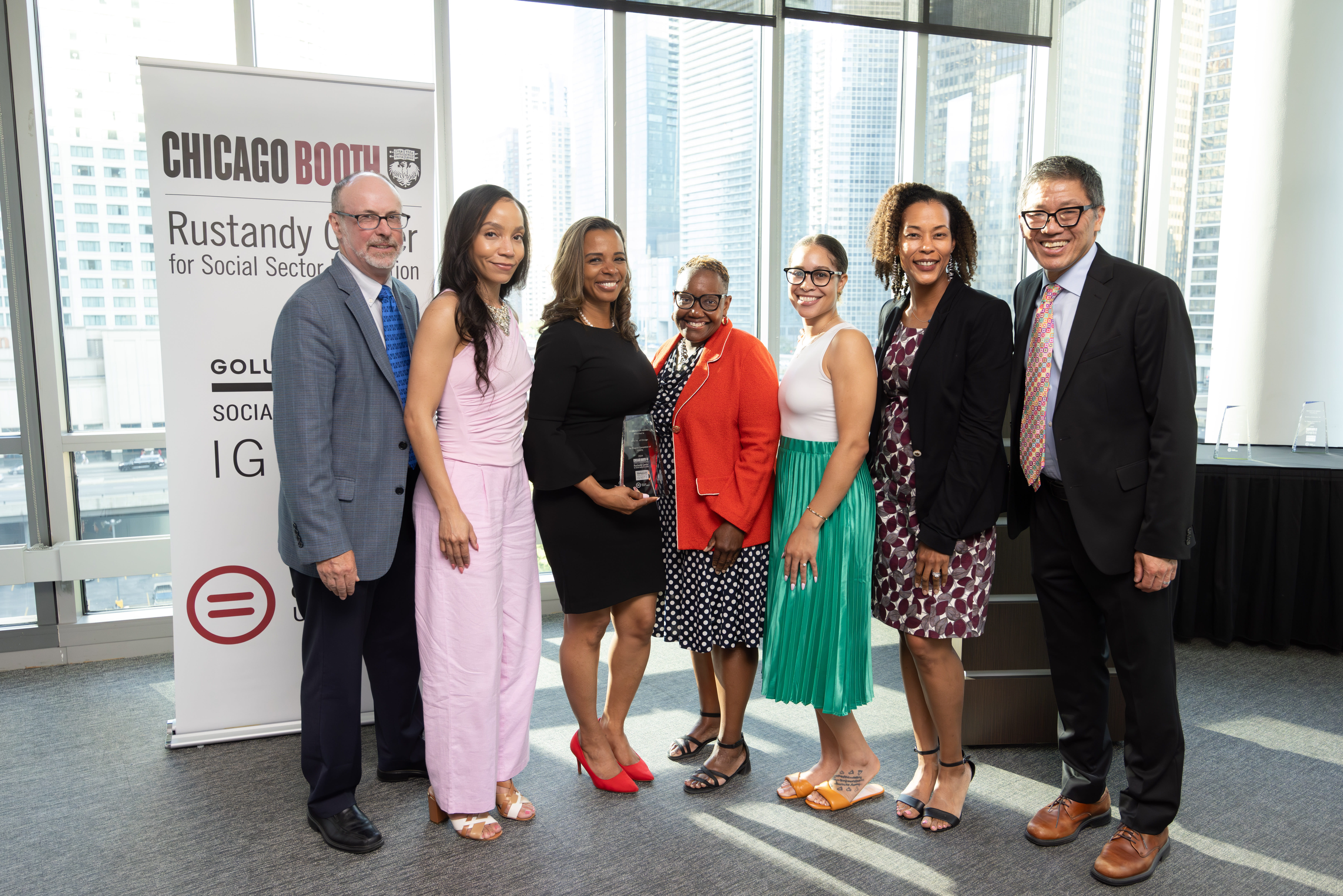 Seven people standing together and smiling at the camera