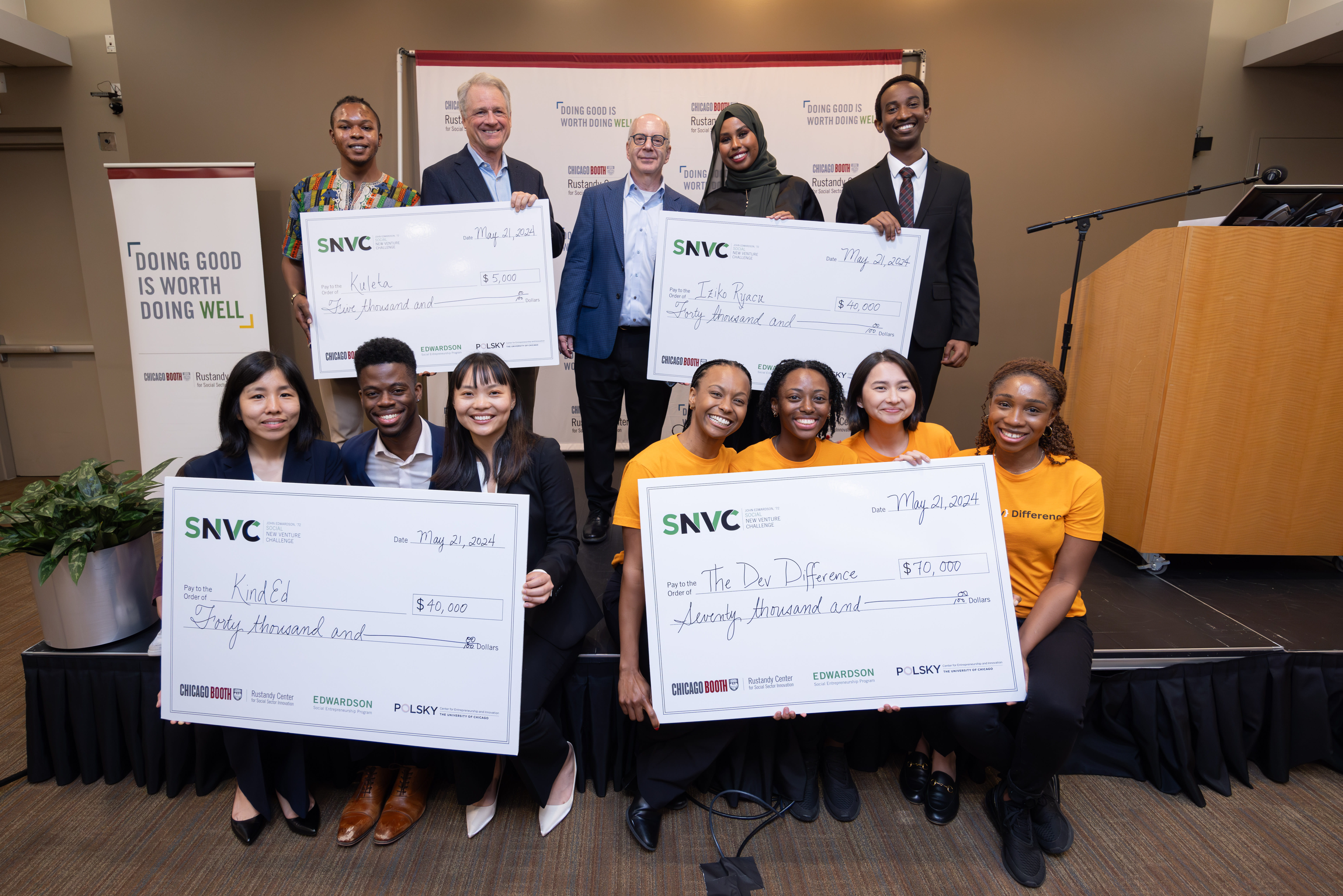 Students displaying giant checks