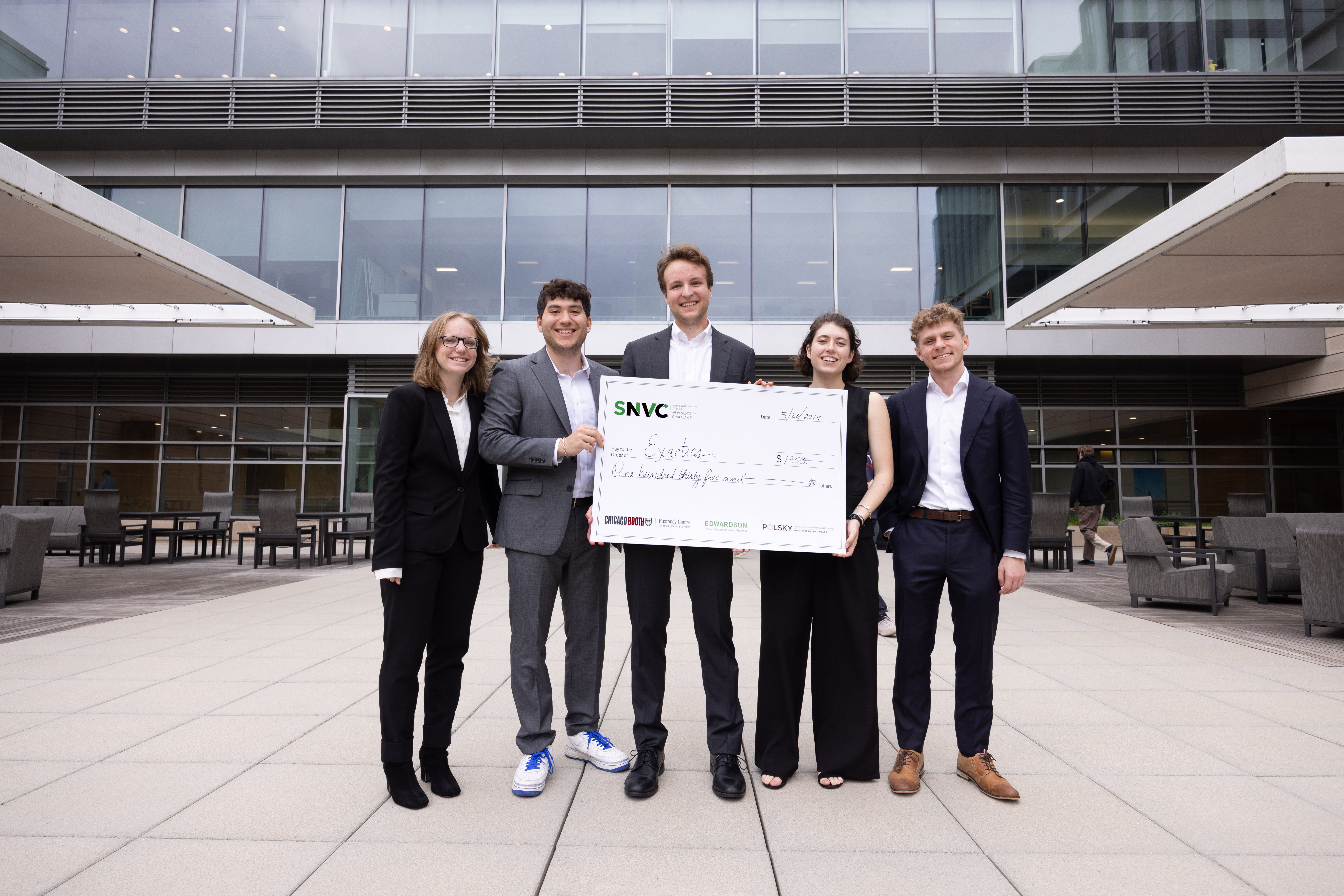 Five people standing together smiling and holding an oversize check