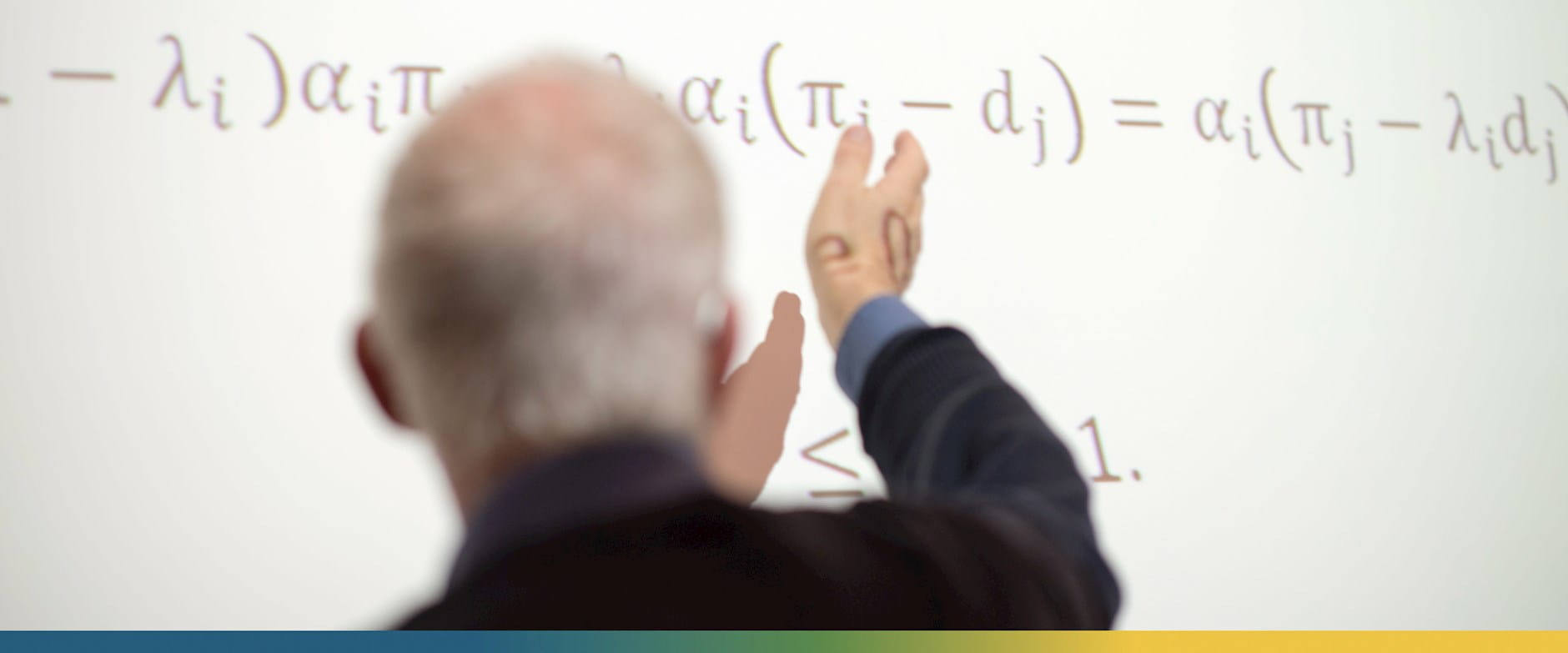 A professor points at an equation on a projector screen