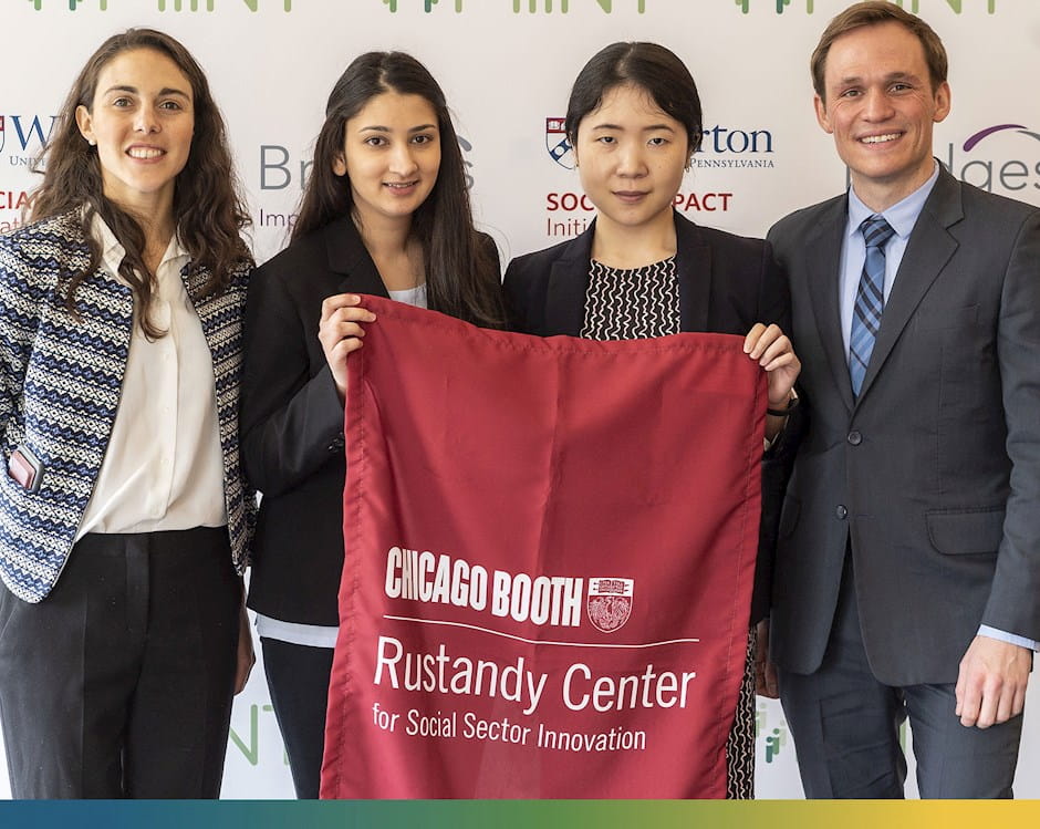 Students holding a red banner which reads “Chicago Booth | Rustandy Center for Social Sector Innovation”