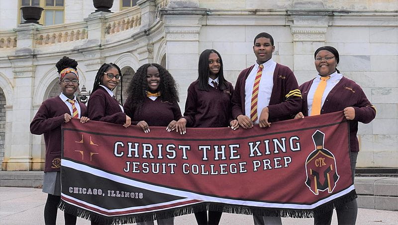 Students holding up banner at Christ the King Jesuit College Prepatory School