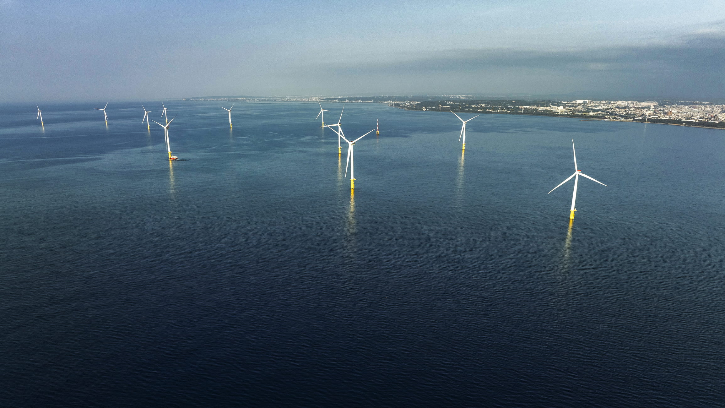 About 10 wind turbines situated in a body of water 