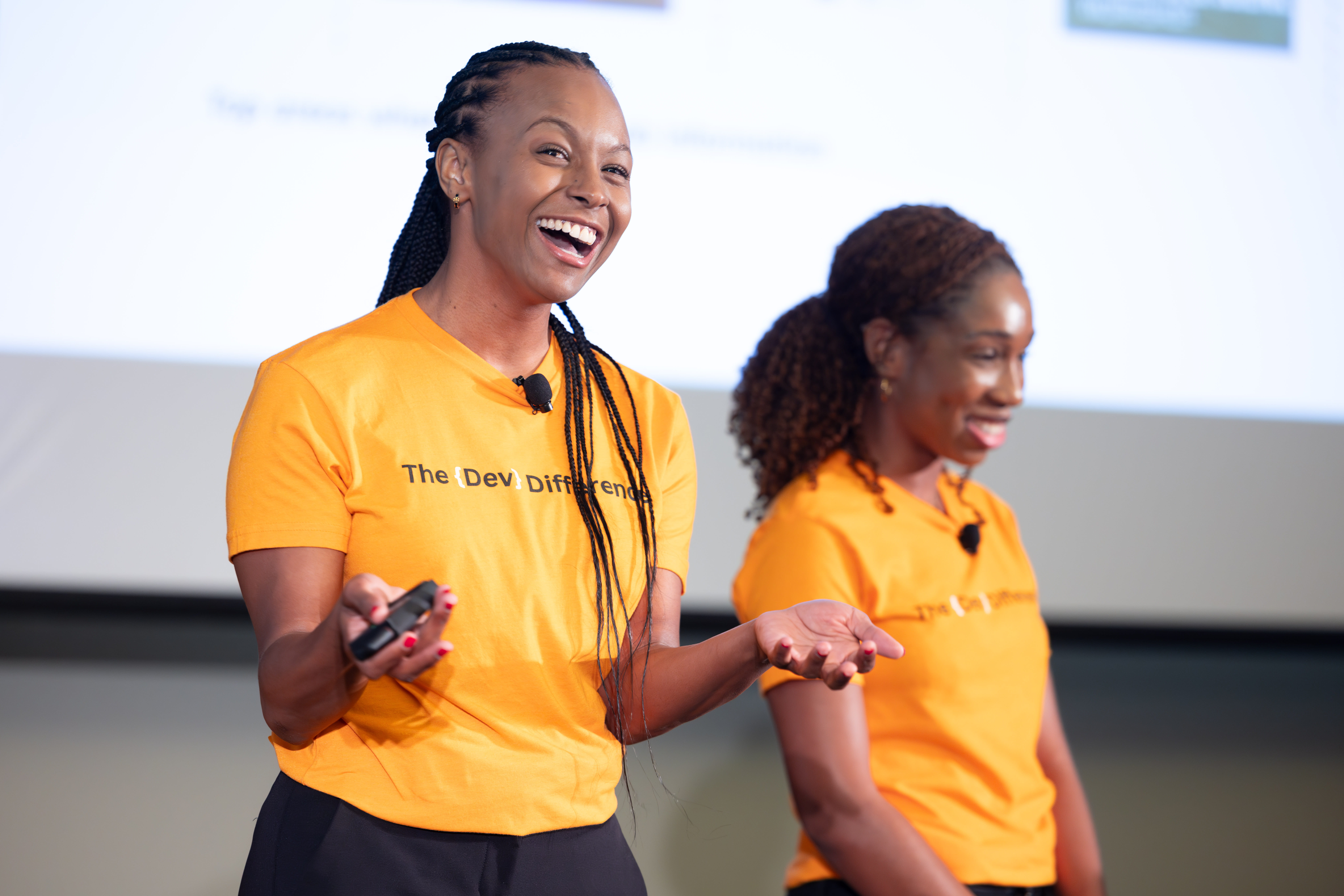 Two women standing on a stage and smiling