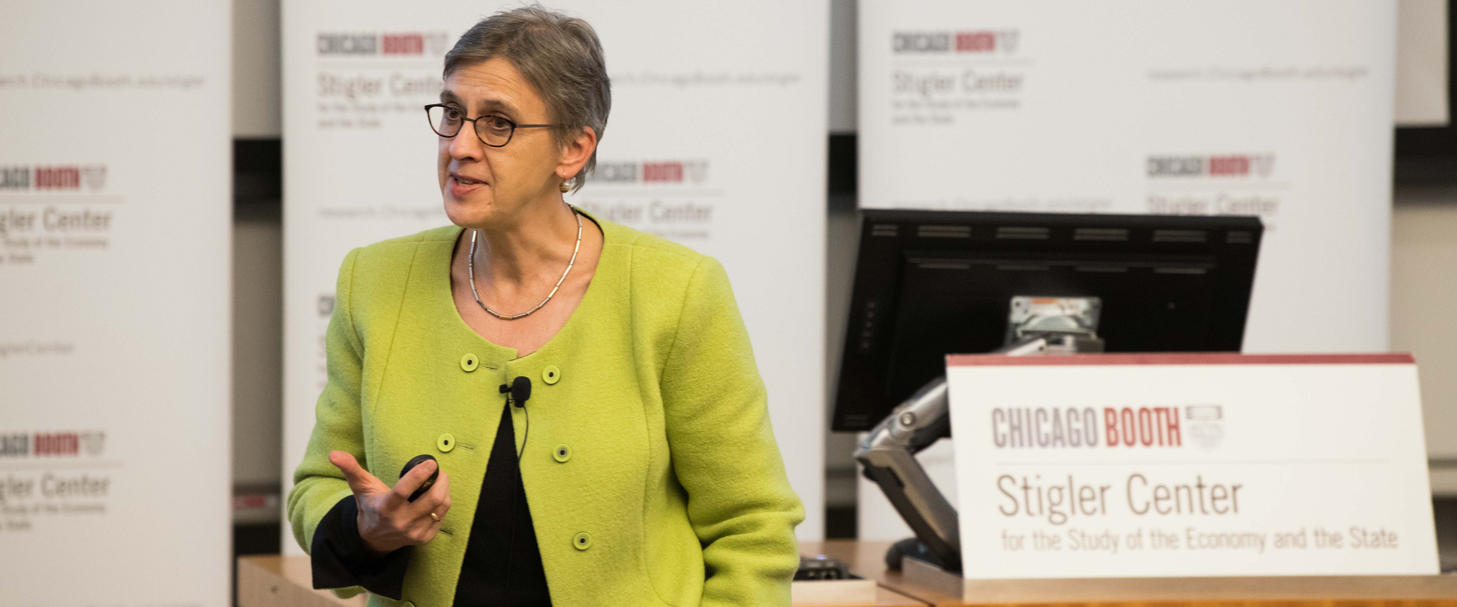 A woman presenting in front of Stigler Center signs