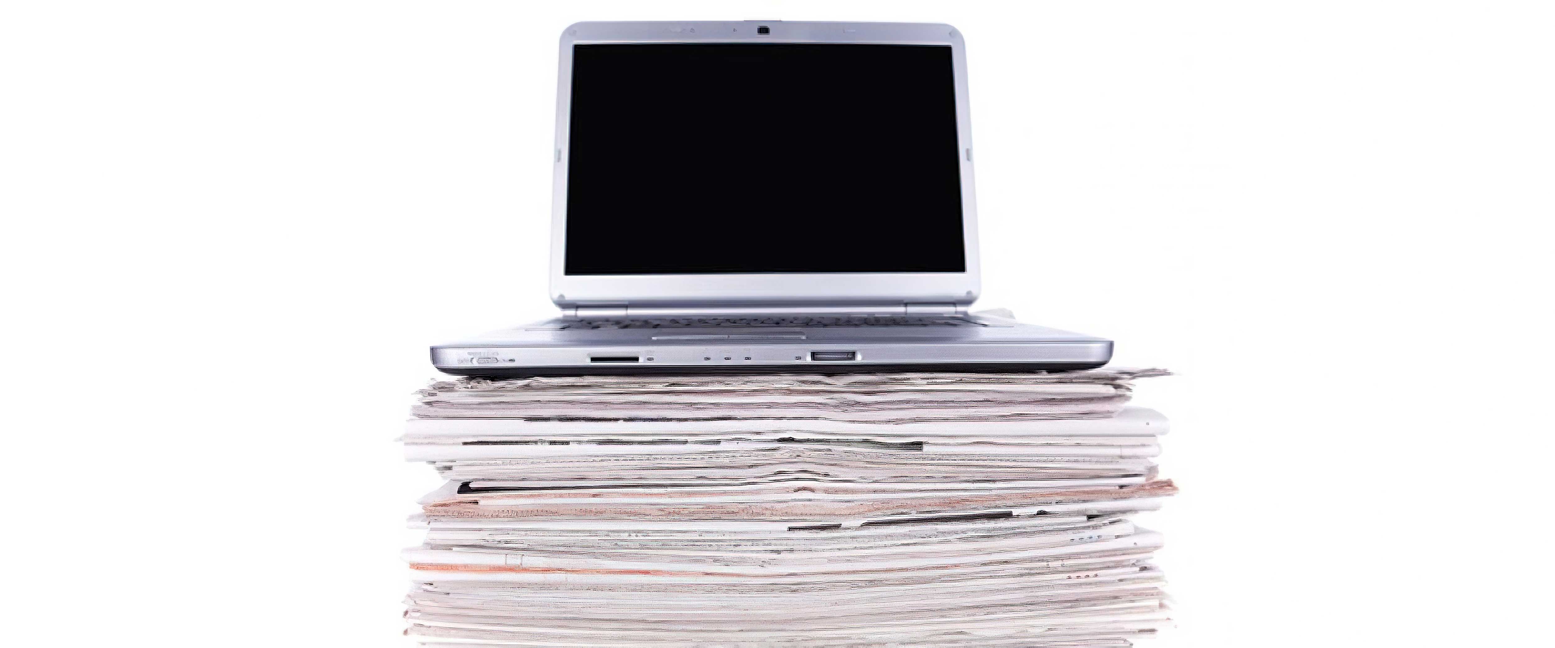 Laptop atop stack of newspapers