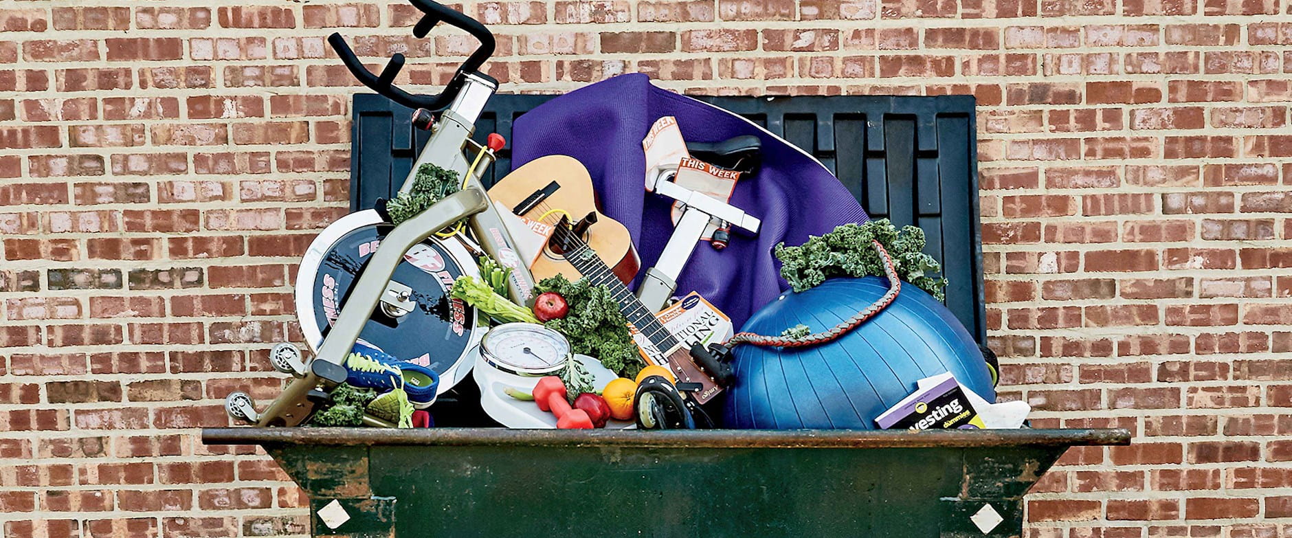 Dumpster filled with hobby items like a guitar and exercise ball