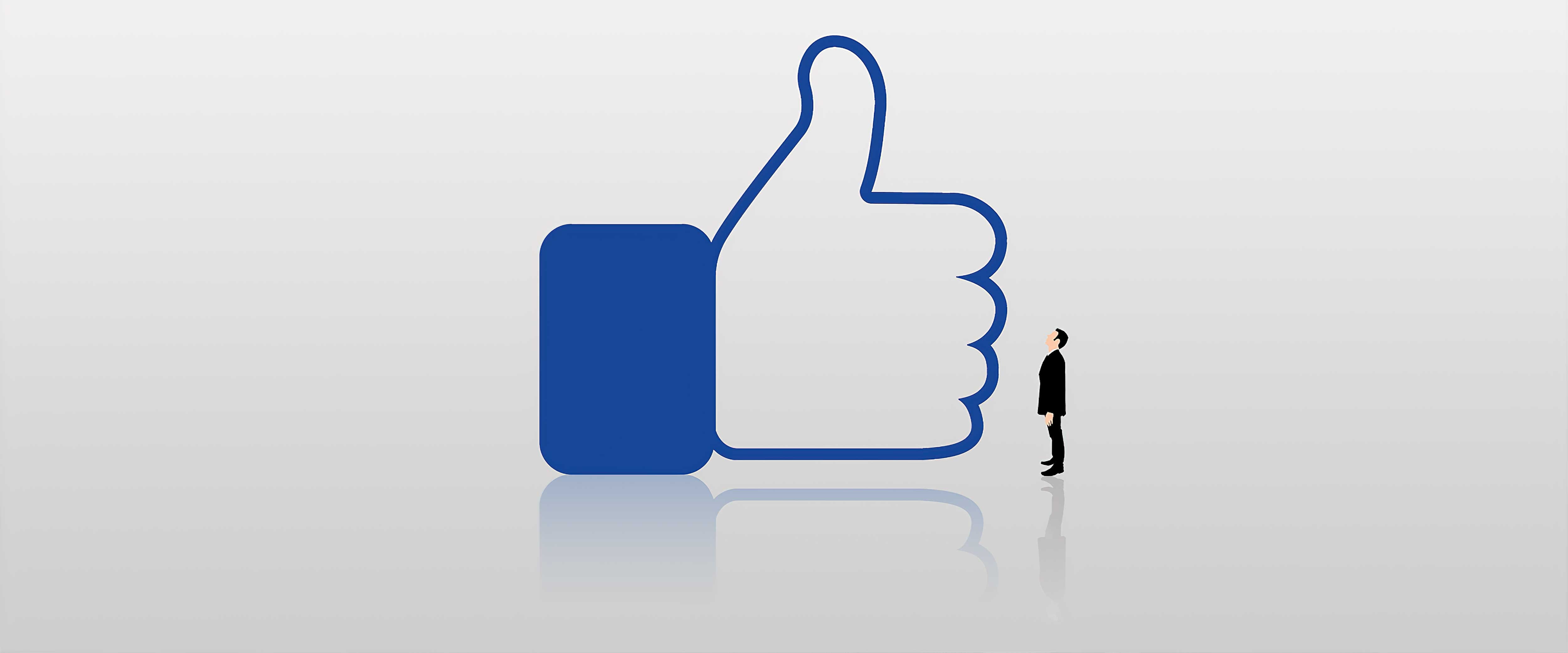 Man looking up at large Facebook thumbs up