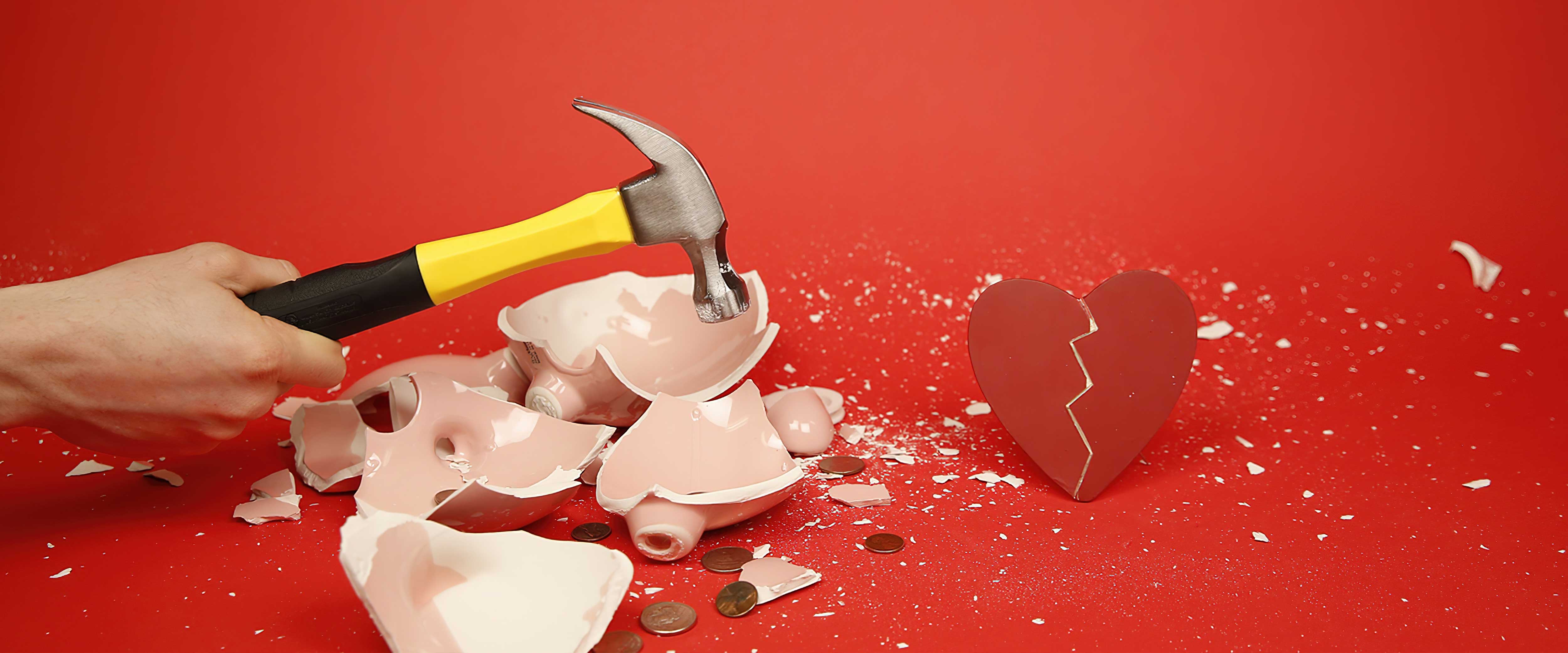 Hammer smashing piggy bank and heart