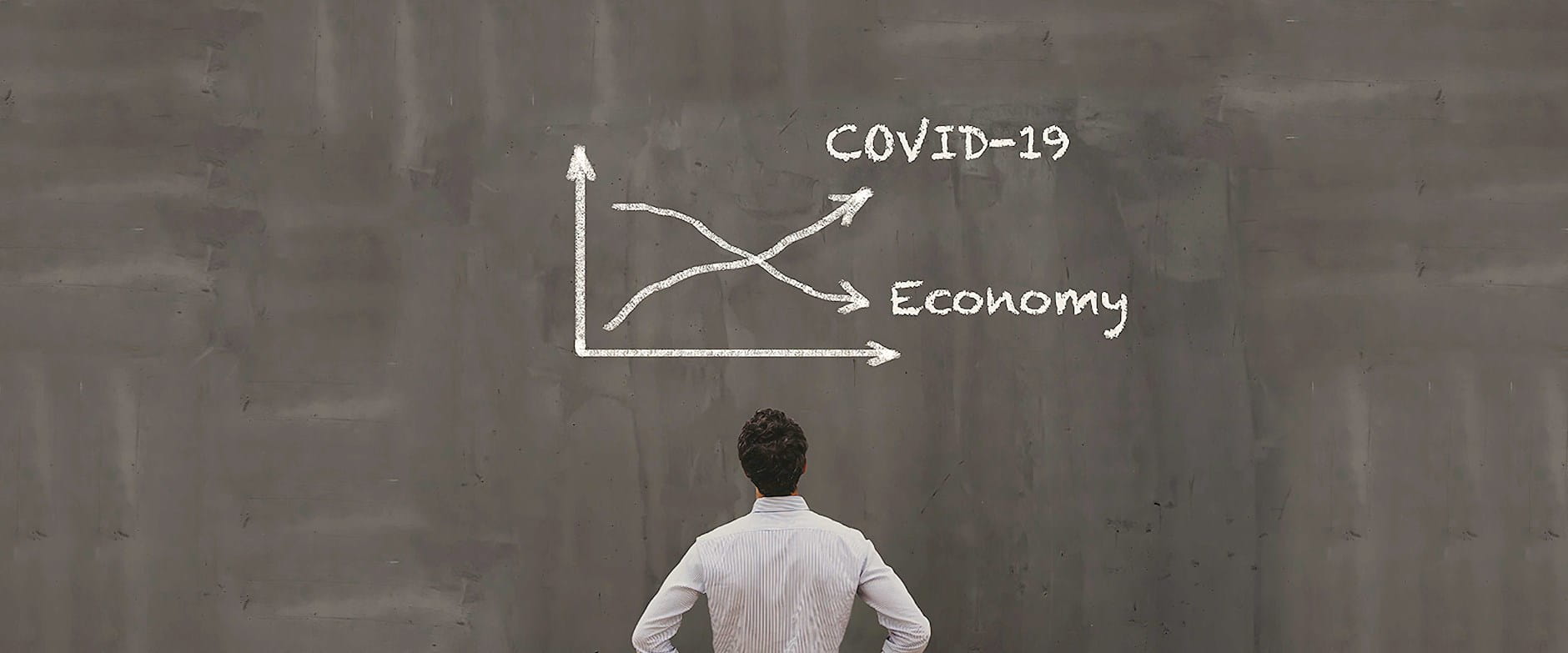 Man looking at covid-19 chart on chalkboard