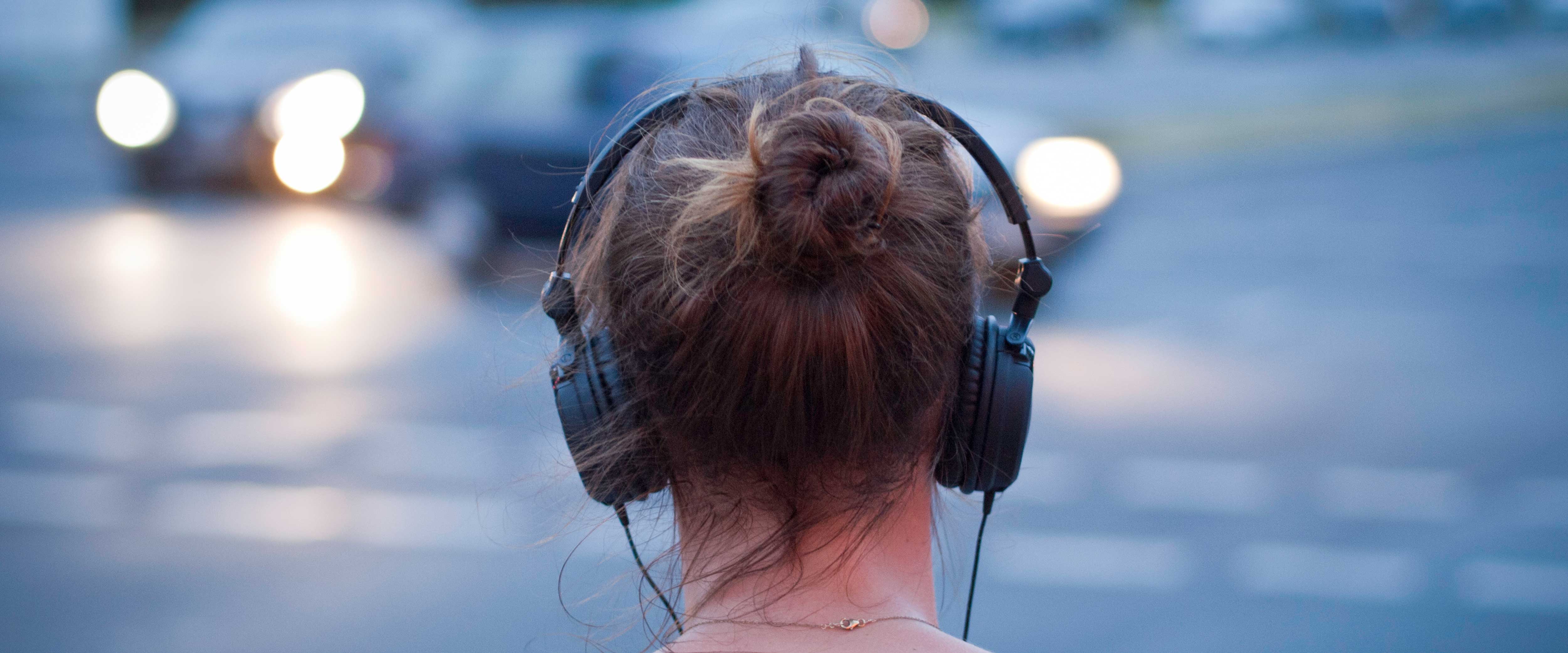 Back of woman's head listening to headphones