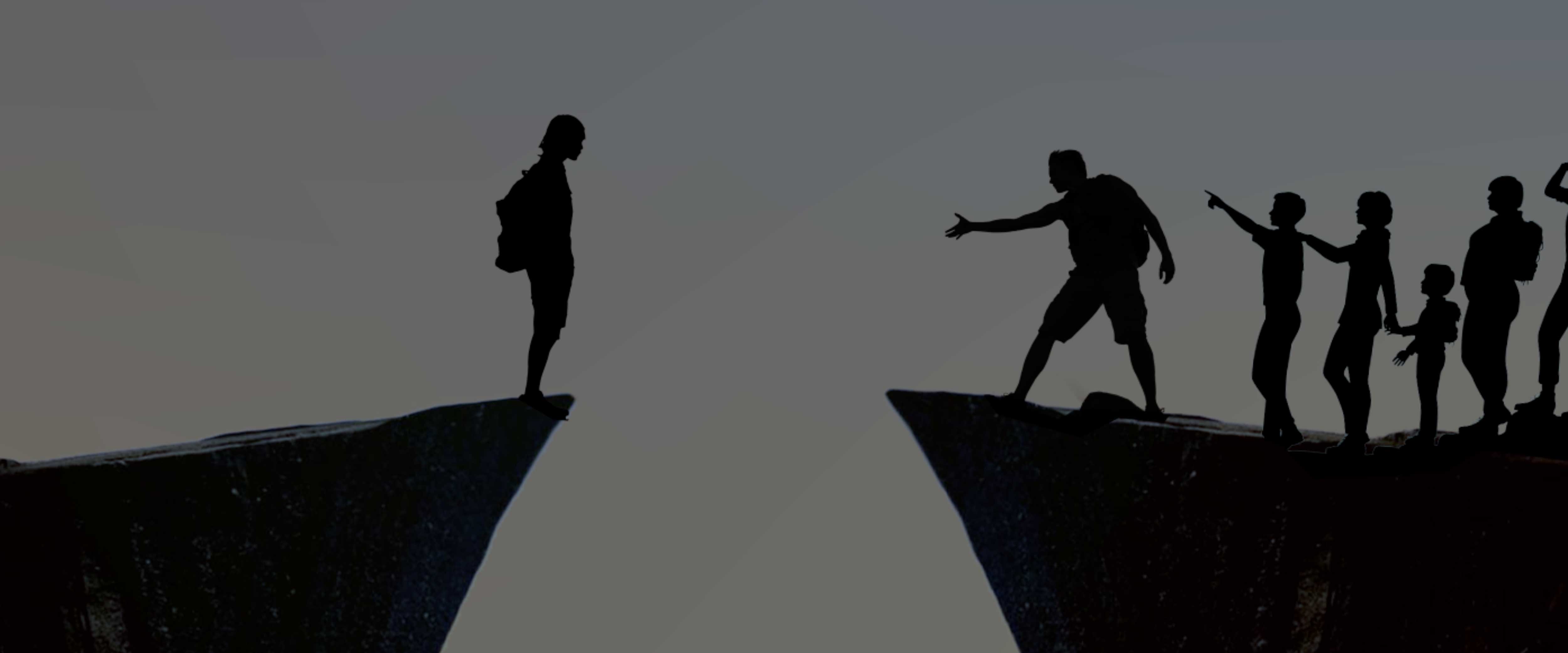 Silhouettes of a group of people crossing a gap between two cliffs, one left behind and the others beckoning them