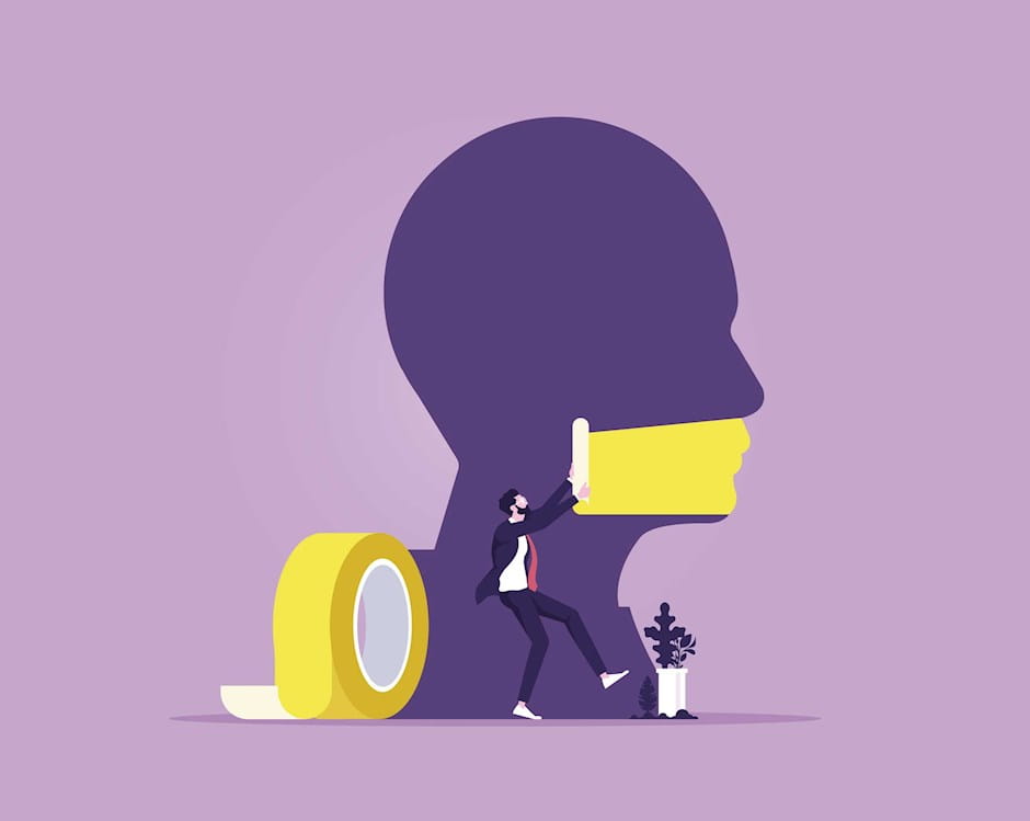 Man putting tape over the mouth of a giant head