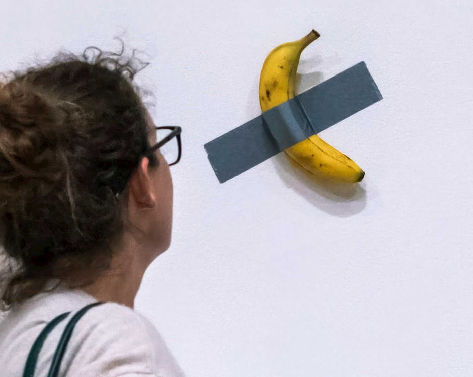 Woman looking at the artwork "Comedian"