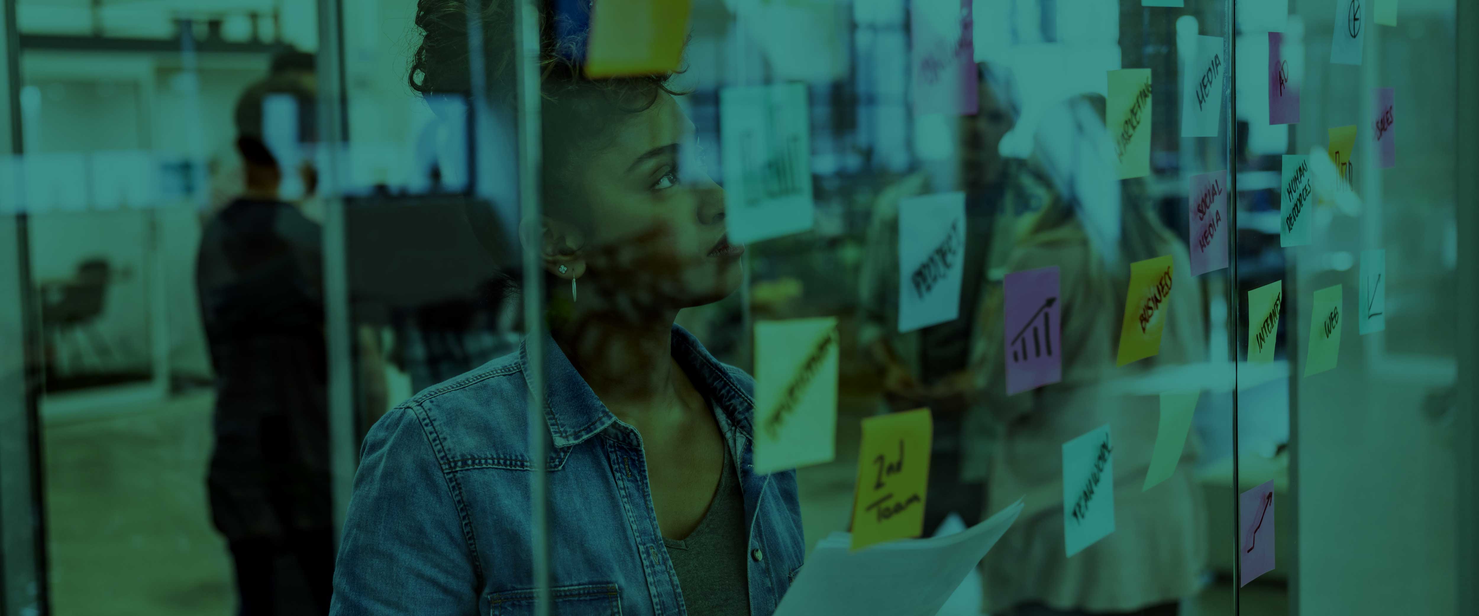Woman standing in front of a window with post it notes