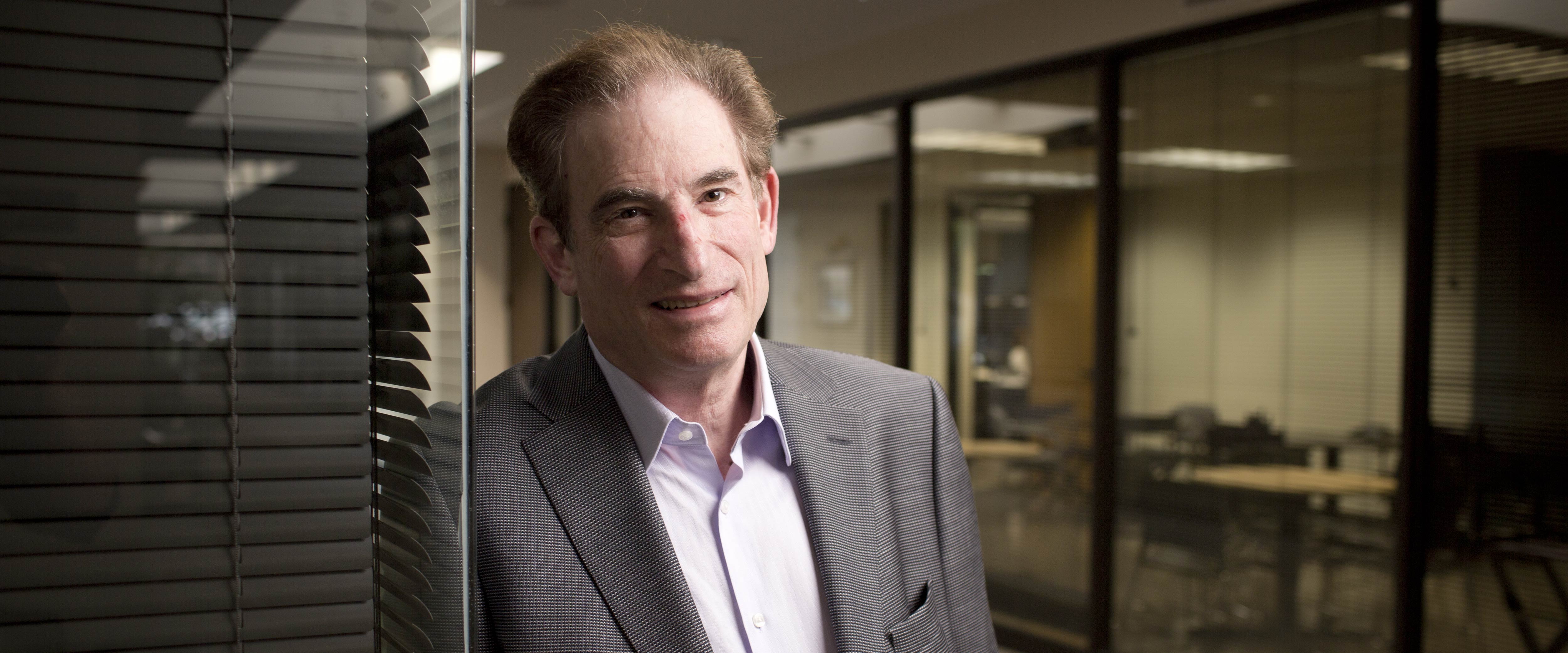 Edward L. Kaplan posing in front of an office 
