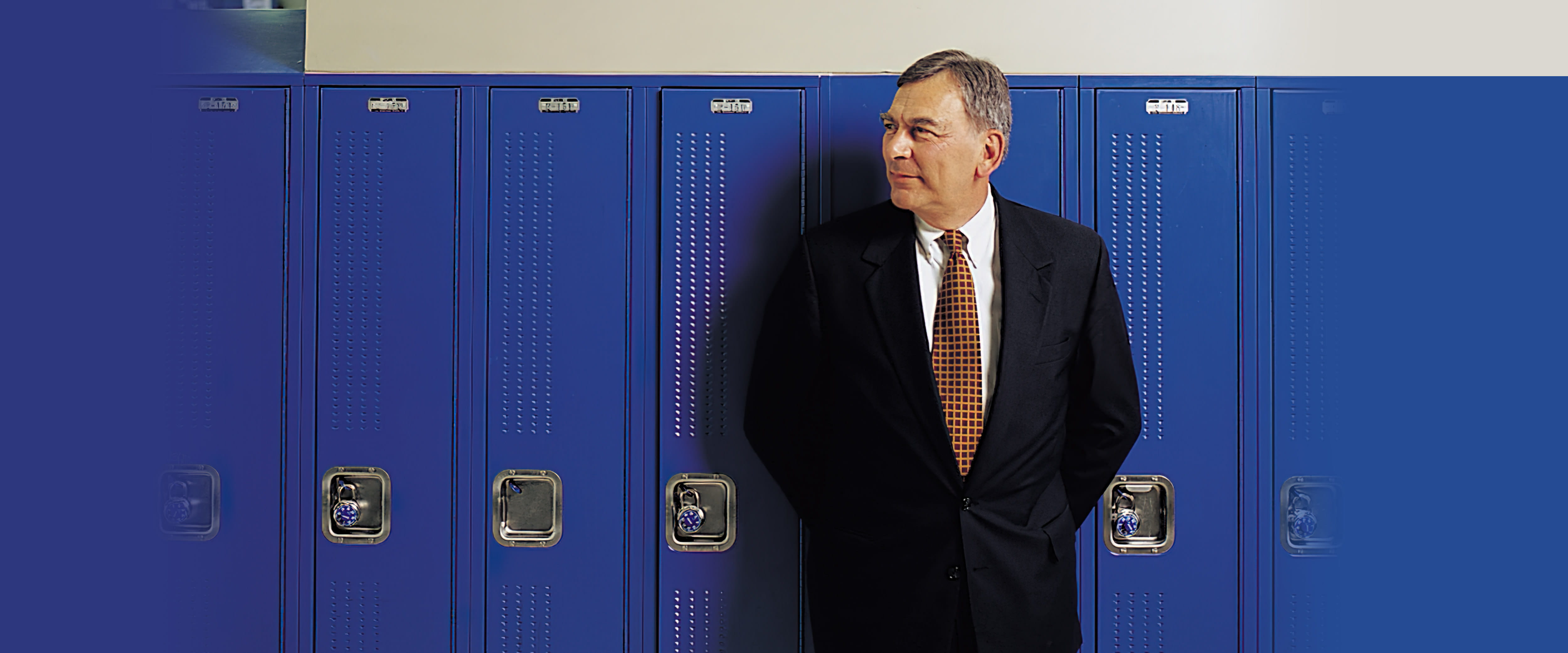 David J. Vitale wearing a suit standing in front of blue lockers