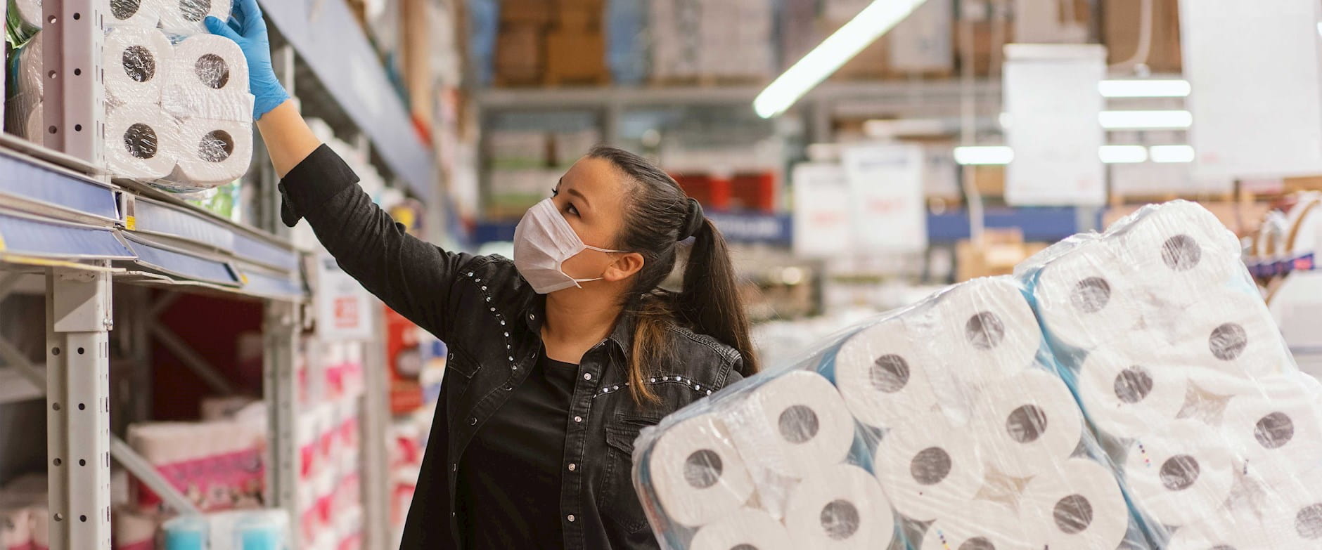A woman buying toilet paper at a warehouse store