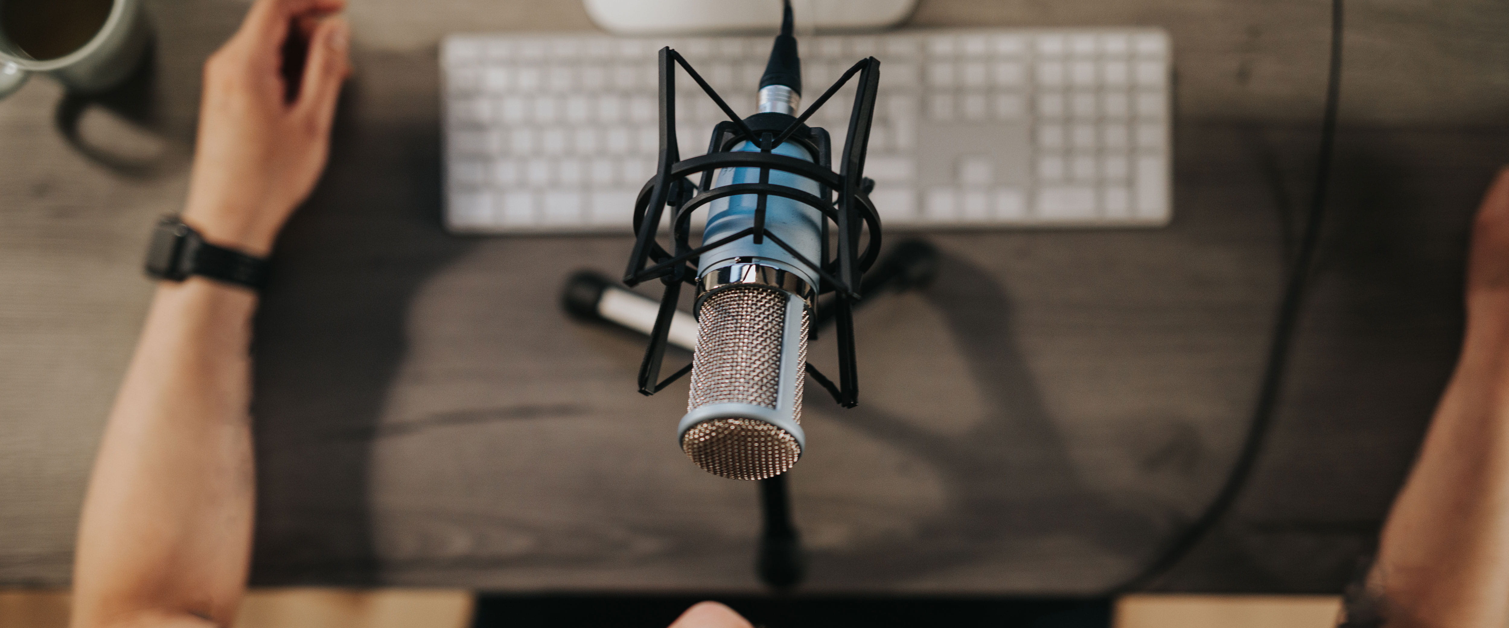Person in front of computer with a microphone