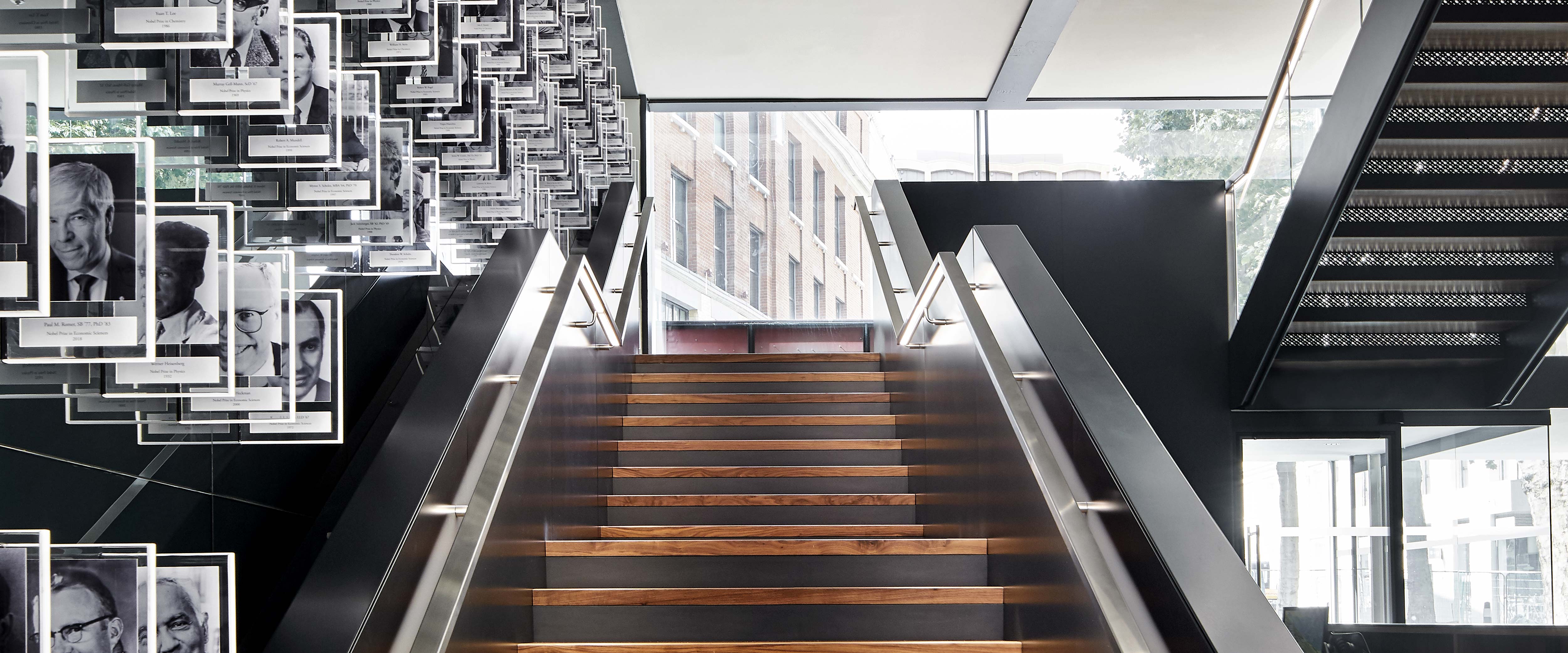 Bright staircase in the lobby of the London Conference Centre; a wall of Nobel Laureate portraits is to the left