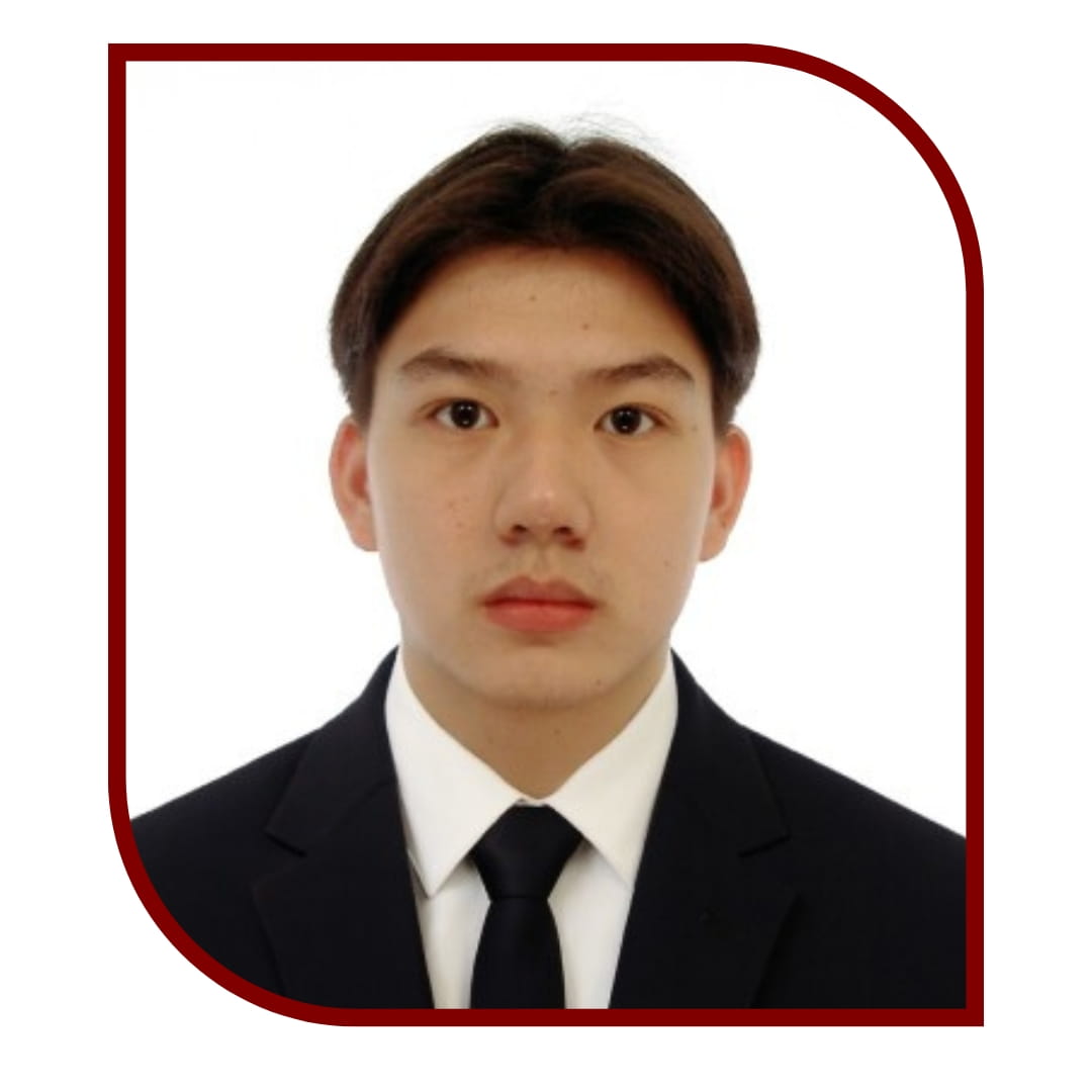 Picture of dark-haired man wearing a black suit and tie. The picture is bordered by a maroon frame. 