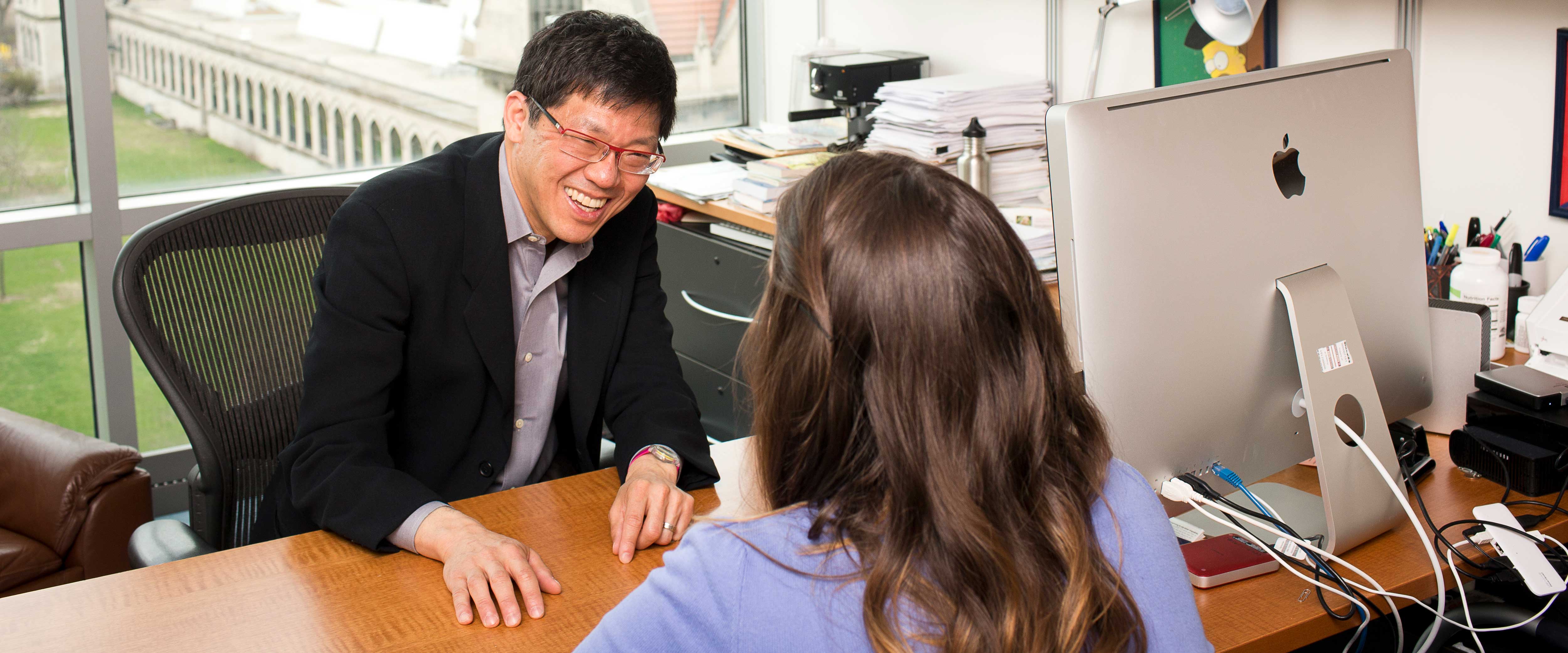 George Wu having a conversation with a student in his office