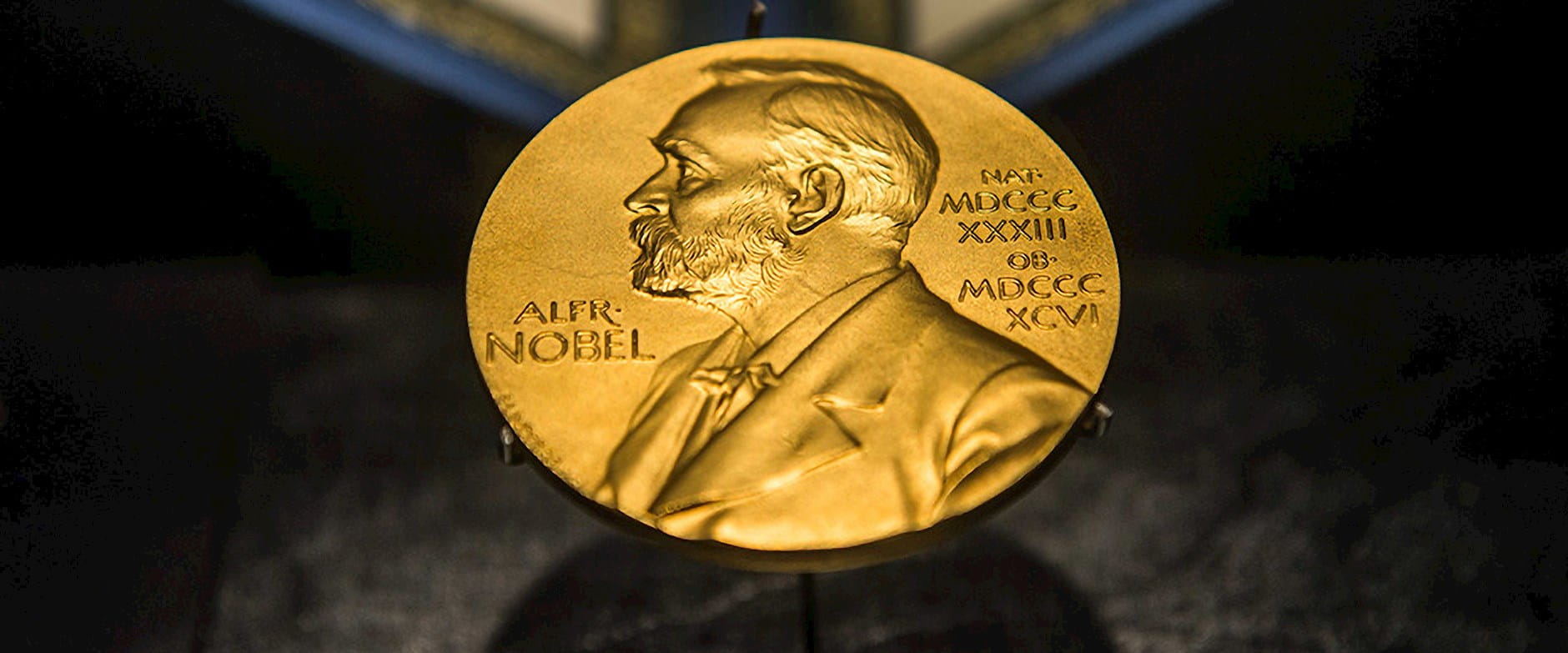 Nobel prize medal centered on a dark background