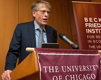Lars Peter Hansen speaks at a podium at the University of Chicago Becker Friedman Institute for Research in Economics